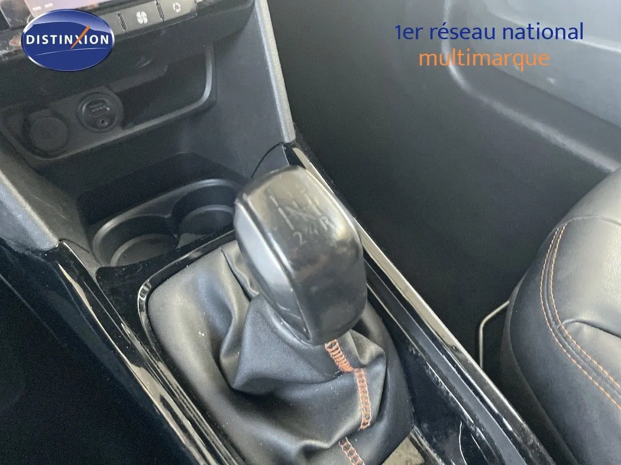 Le levier de vitesse en gros plan de la Peugeot 2008 gris platinium, avec coutures apparentes sur la sellerie noire.