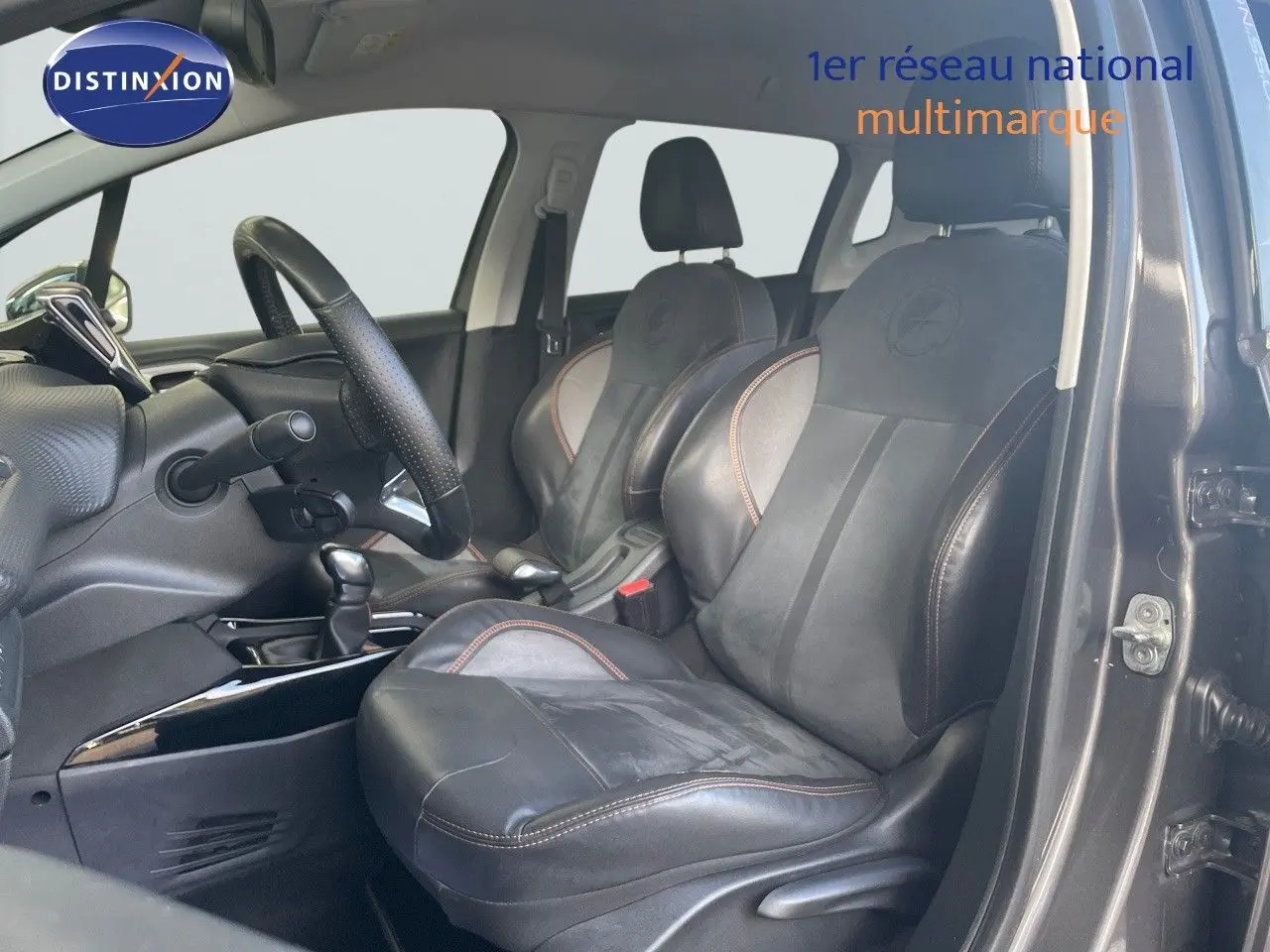 Intérieur du Peugeot 2008 2019 avec sièges cuir noir et surpiqûres orange, vue côté gauche porte ouverte.