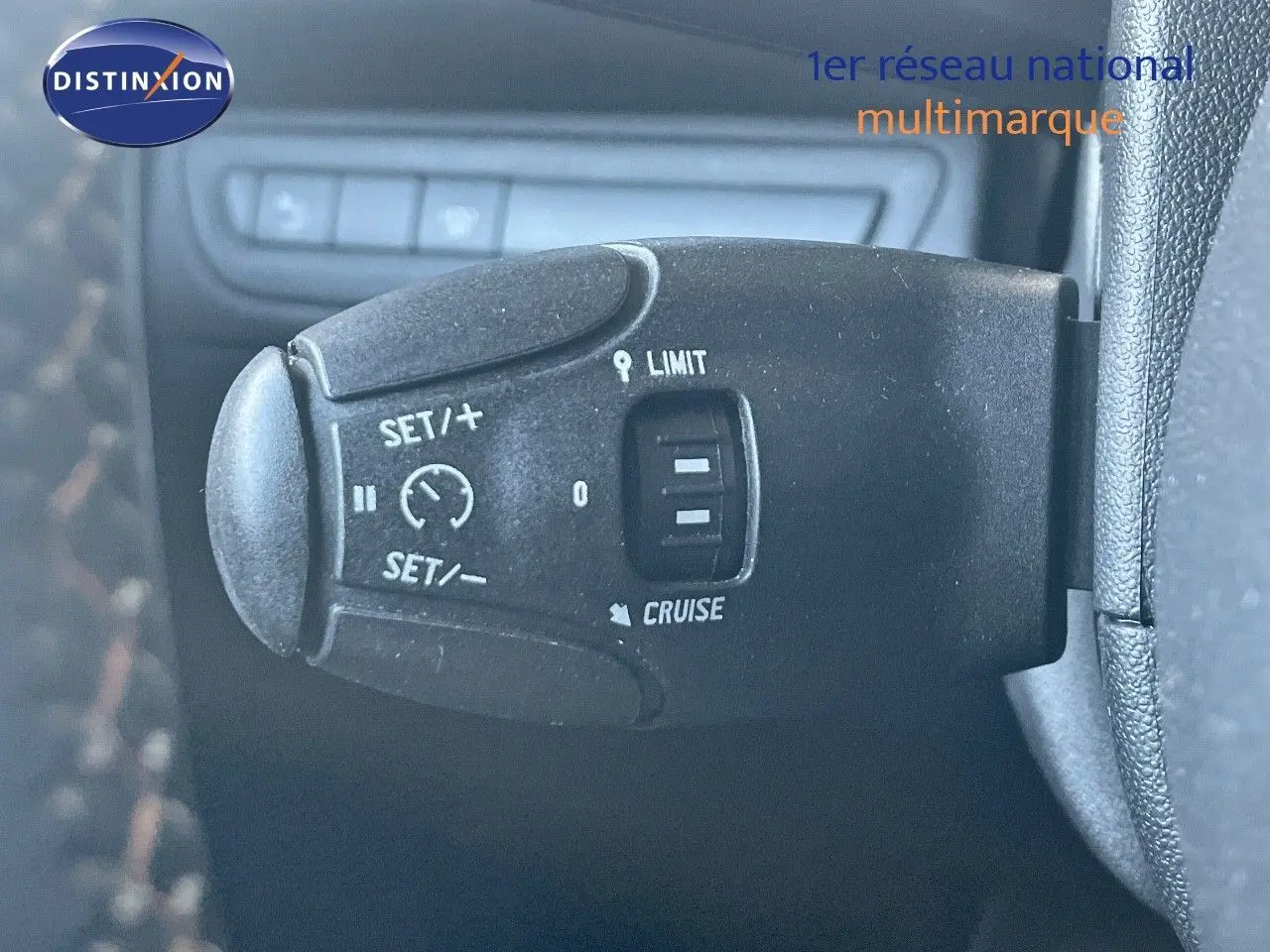 Gros plan sur la commande de régulateur de vitesse du Peugeot 2008 gris platinium, côté gauche du volant.