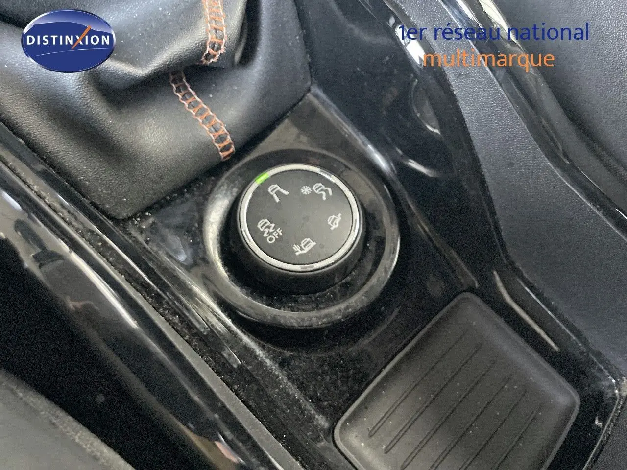 Gros plan sur la molette de sélection des modes de conduite dans l'habitacle noir d'une Peugeot 2008 gris platinium.