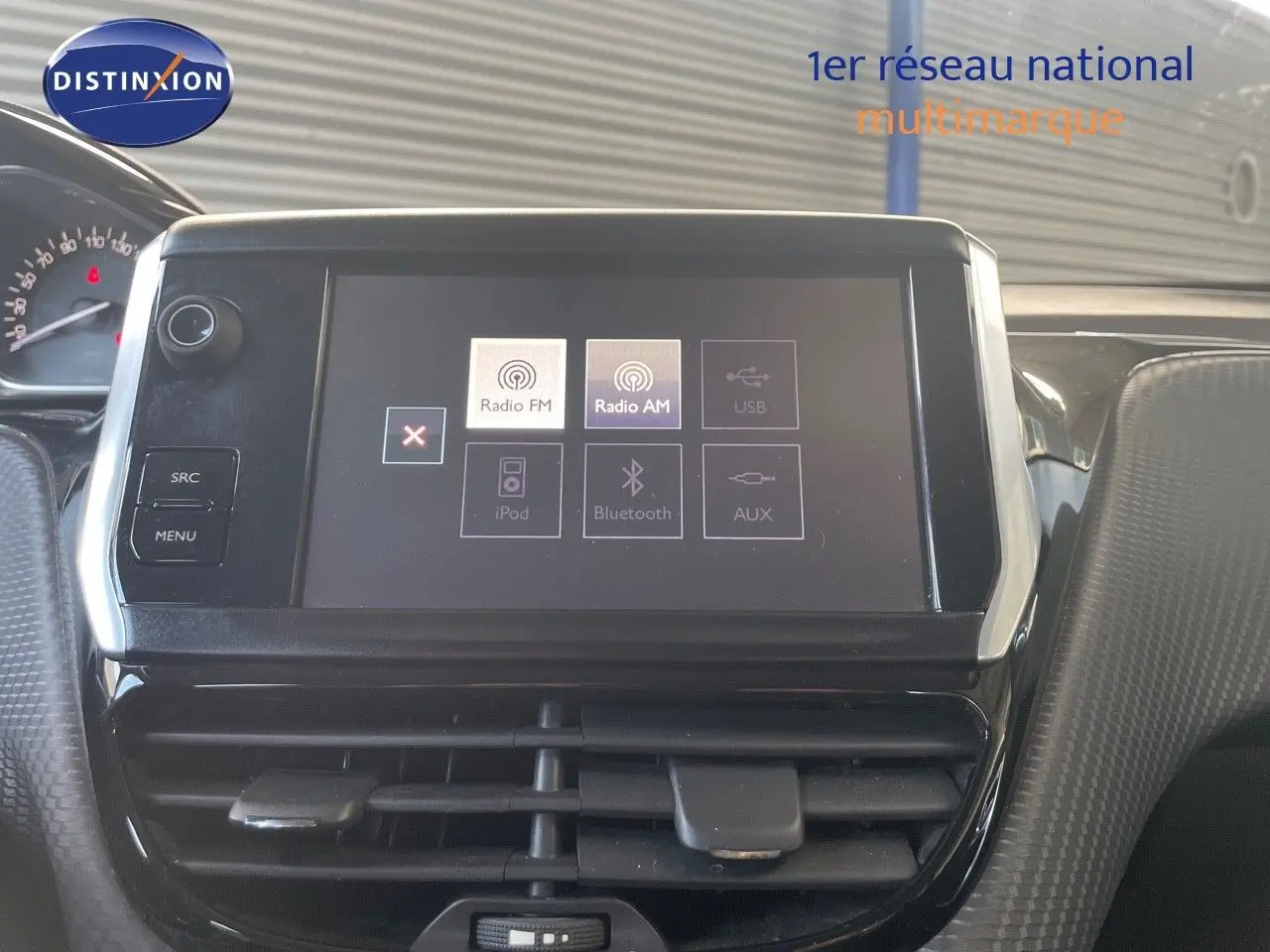 Écran tactile central du tableau de bord d'une Peugeot 2008 gris platinium, avec options radio et Bluetooth visibles.