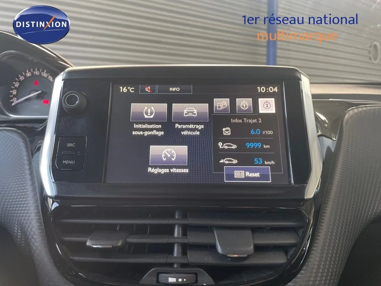 Écran tactile central du tableau de bord du Peugeot 2008 gris platinium, affichant les réglages du véhicule et infos trajet.