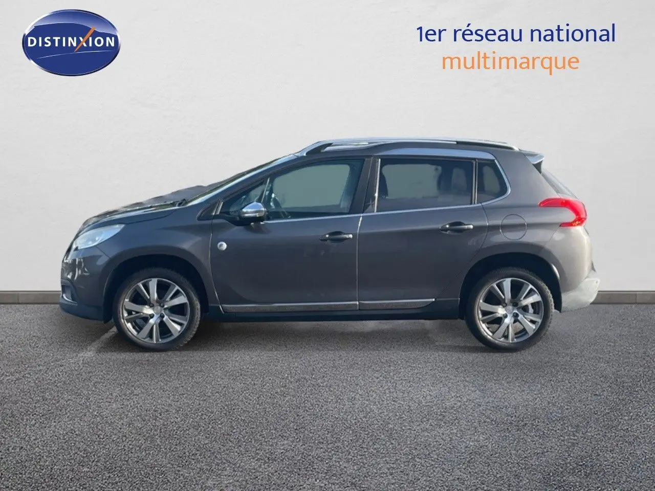 Profil côté gauche d'un Peugeot 2008 gris platinium métallisé, avec jantes alliage et toit panoramique visible.