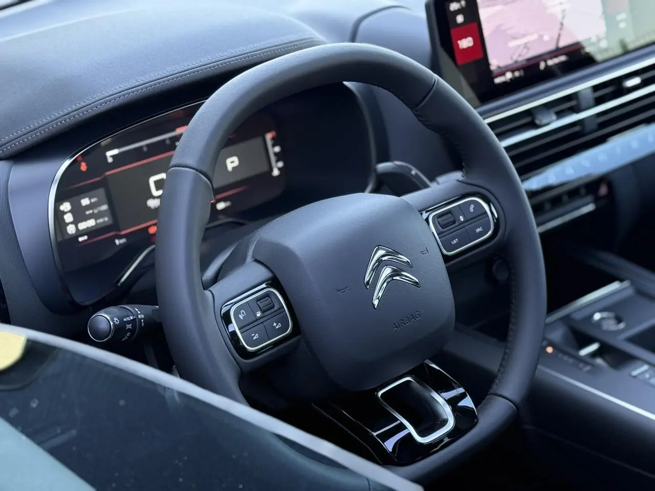 Vue rapprochée du volant noir et du tableau de bord numérique du Citroën C5 Aircross 2025, intérieur moderne.