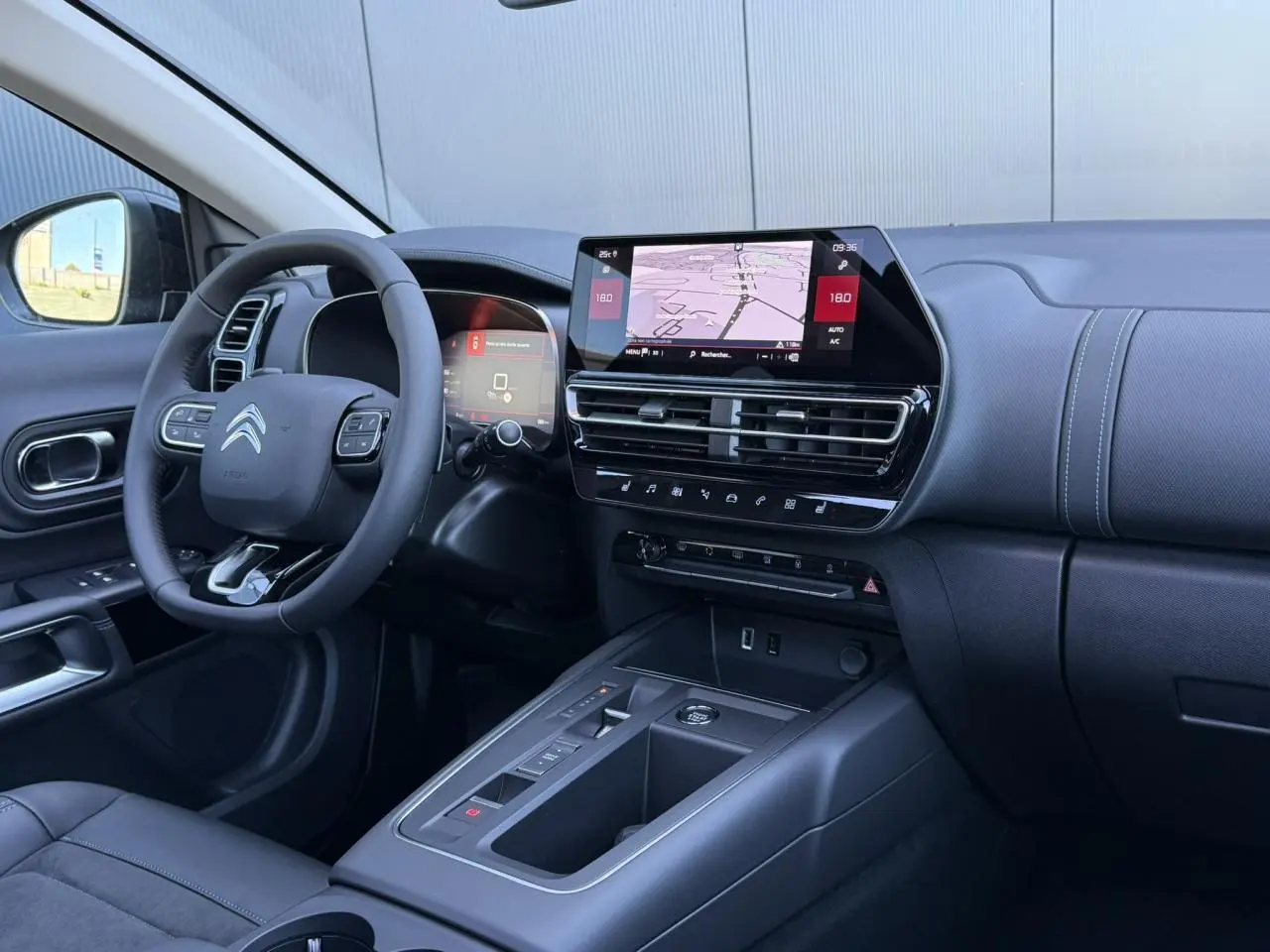 Intérieur noir du Citroën C5 Aircross 2025, vue côté conducteur sur tableau de bord et écran tactile GPS.