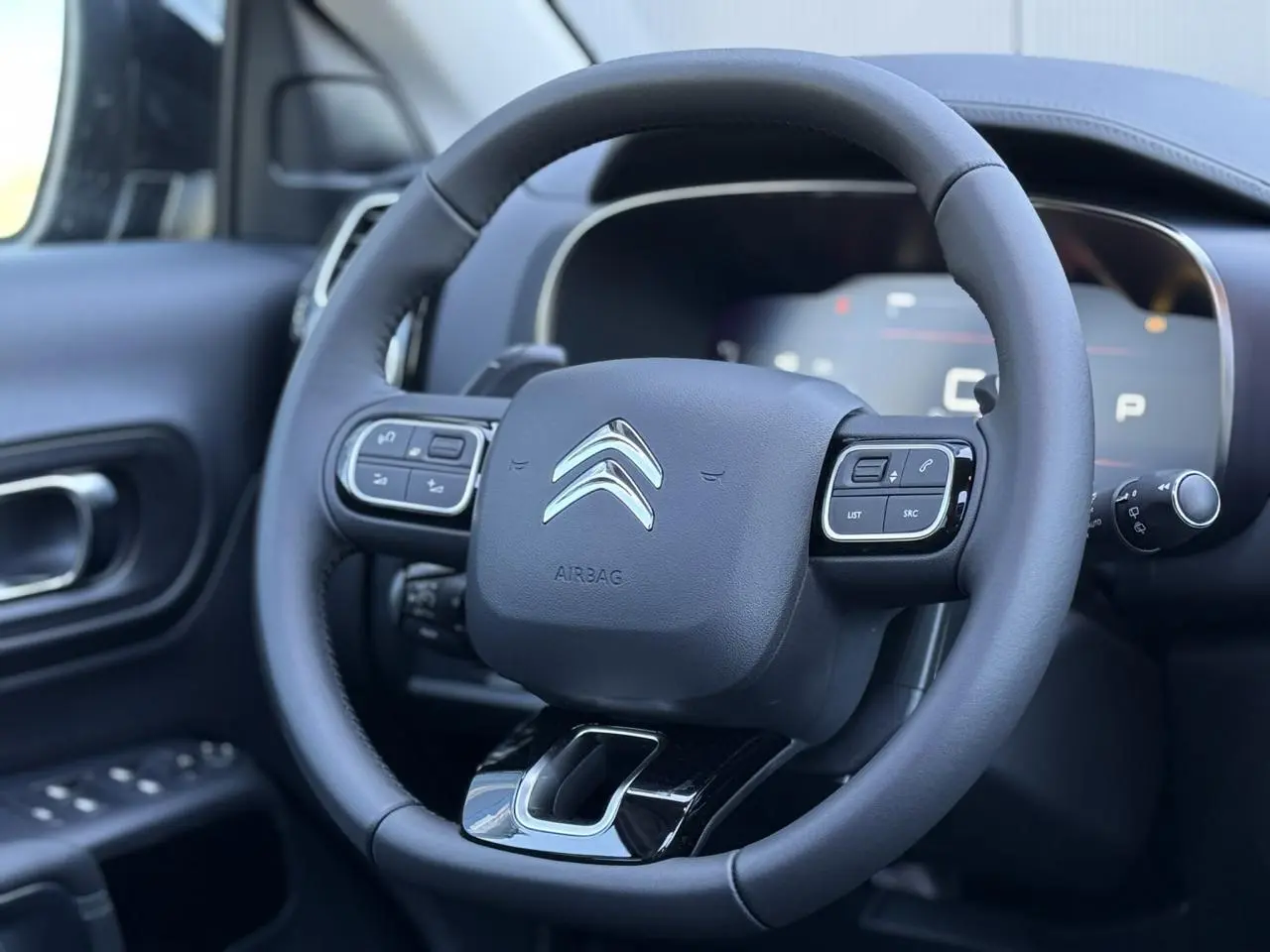 Volant cuir noir avec commandes intégrées du Citroën C5 Aircross 2025, vue rapprochée côté conducteur intérieur