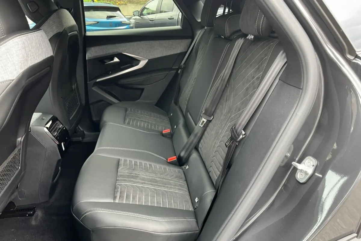 Vue côté droit de la banquette arrière en cuir alcantara gris foncé du Peugeot 3008 Hybrid 145 GT avec ceinture noire.