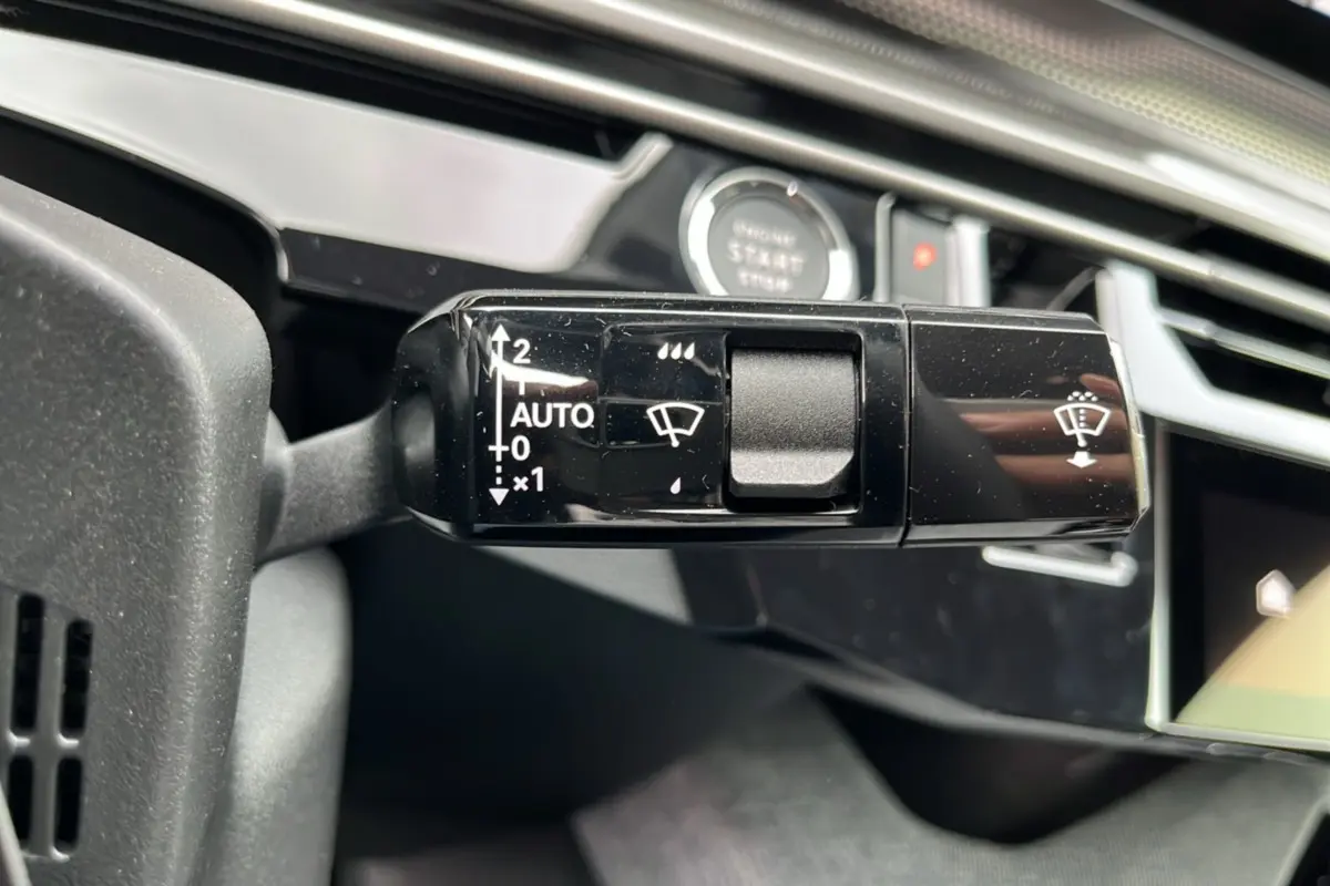 Gros plan sur la commande d'essuie-glace du Peugeot 3008 Hybrid 145 GT Alcantara, intérieur noir et détails modernes.