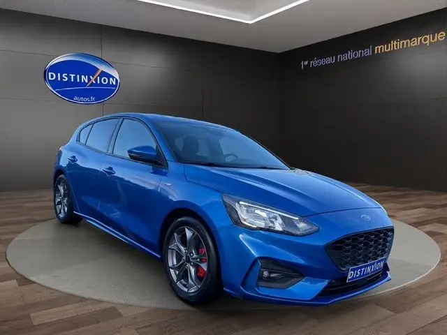 Vue 3/4 avant d'une Ford Focus 1.5 EcoBoost 150ch ST-Line BVA bleu vif avec jantes alliage et étriers rouges.
