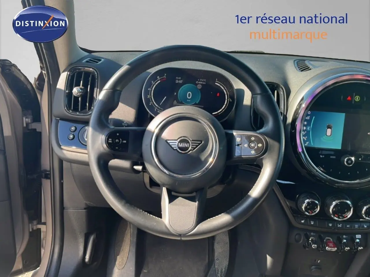 Vue intérieure centrée sur le volant et le tableau de bord numérique d'une MINI Countryman 2023, finition Essential.