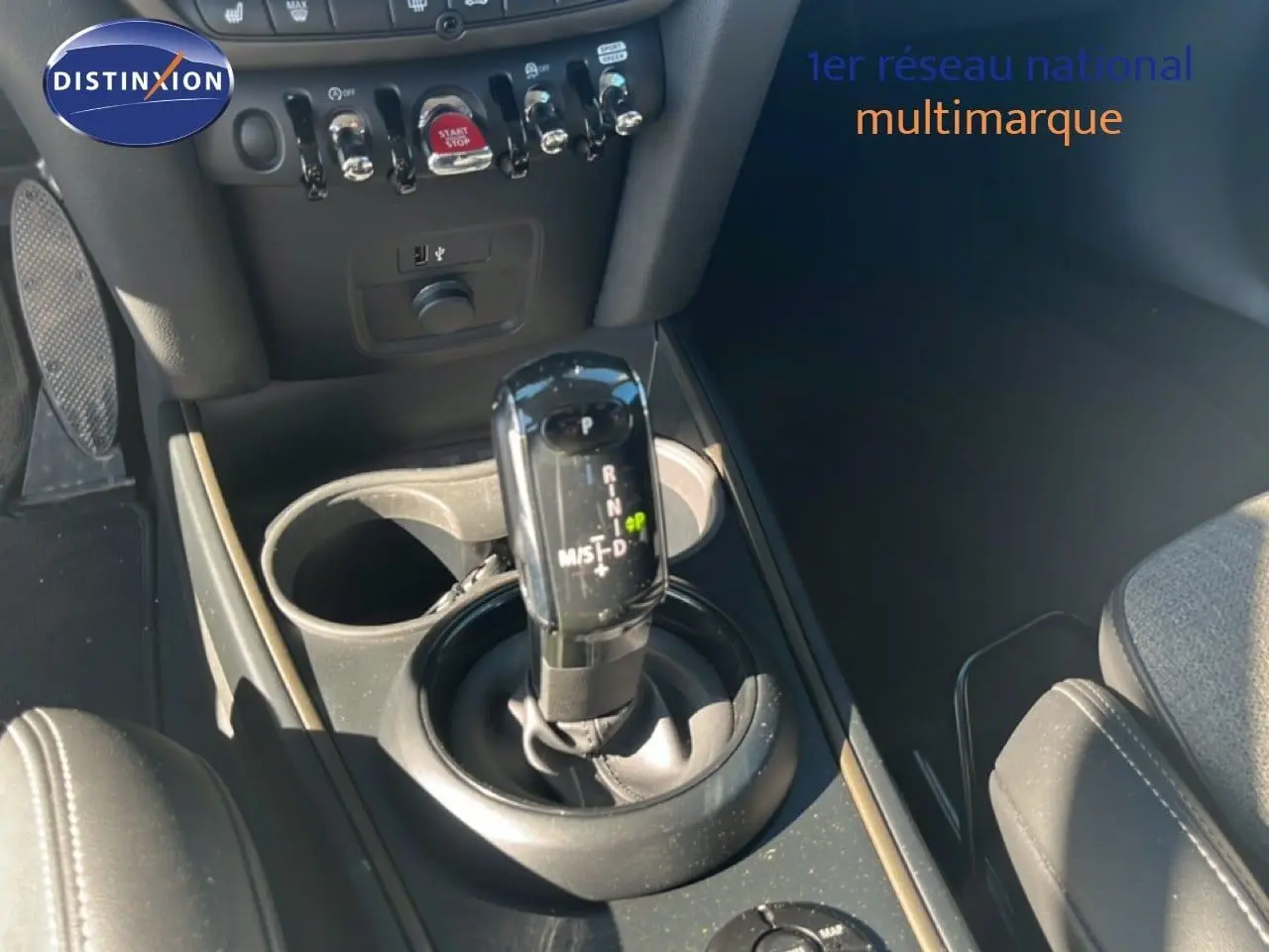 Gros plan sur la console centrale du MINI Countryman 2023, montrant le levier de vitesse automatique et les commandes environnantes.