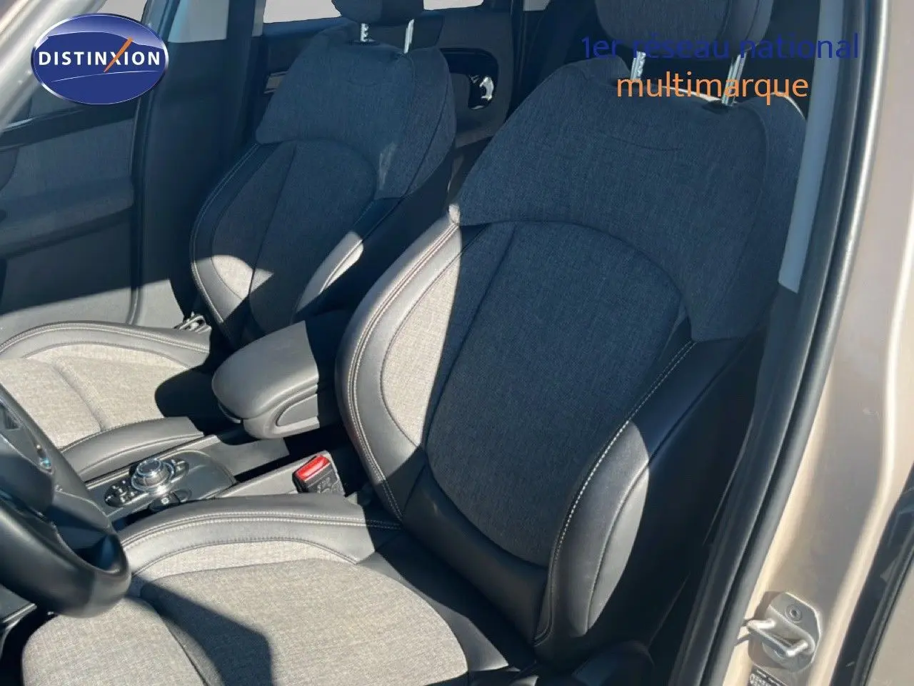 Vue intérieure côté avant droit du MINI Countryman 2023 avec sièges tissu gris et cuir noir, porte ouverte.