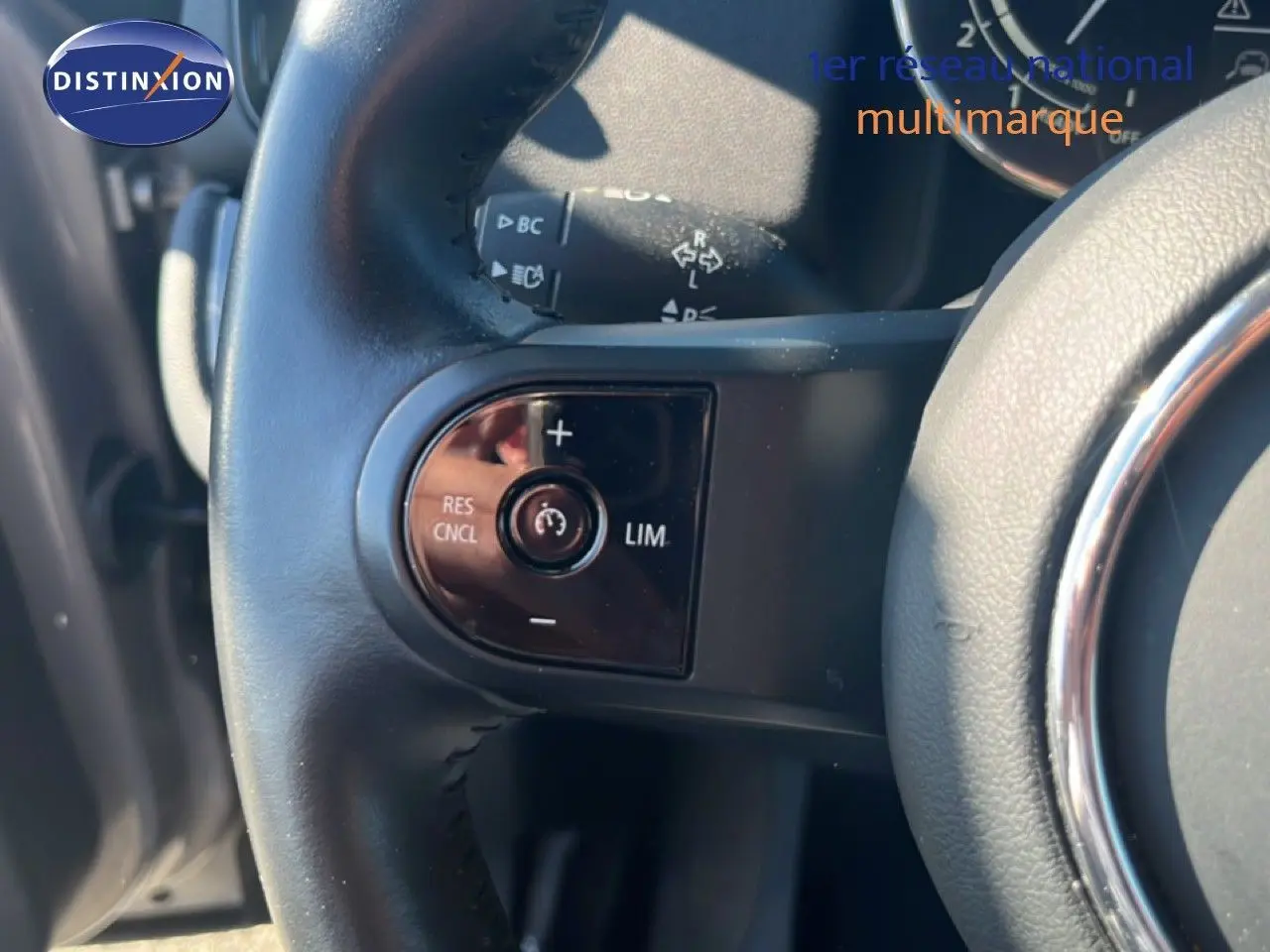 Gros plan sur la partie gauche du volant en cuir noir du MINI Countryman 2023, avec commandes intégrées.