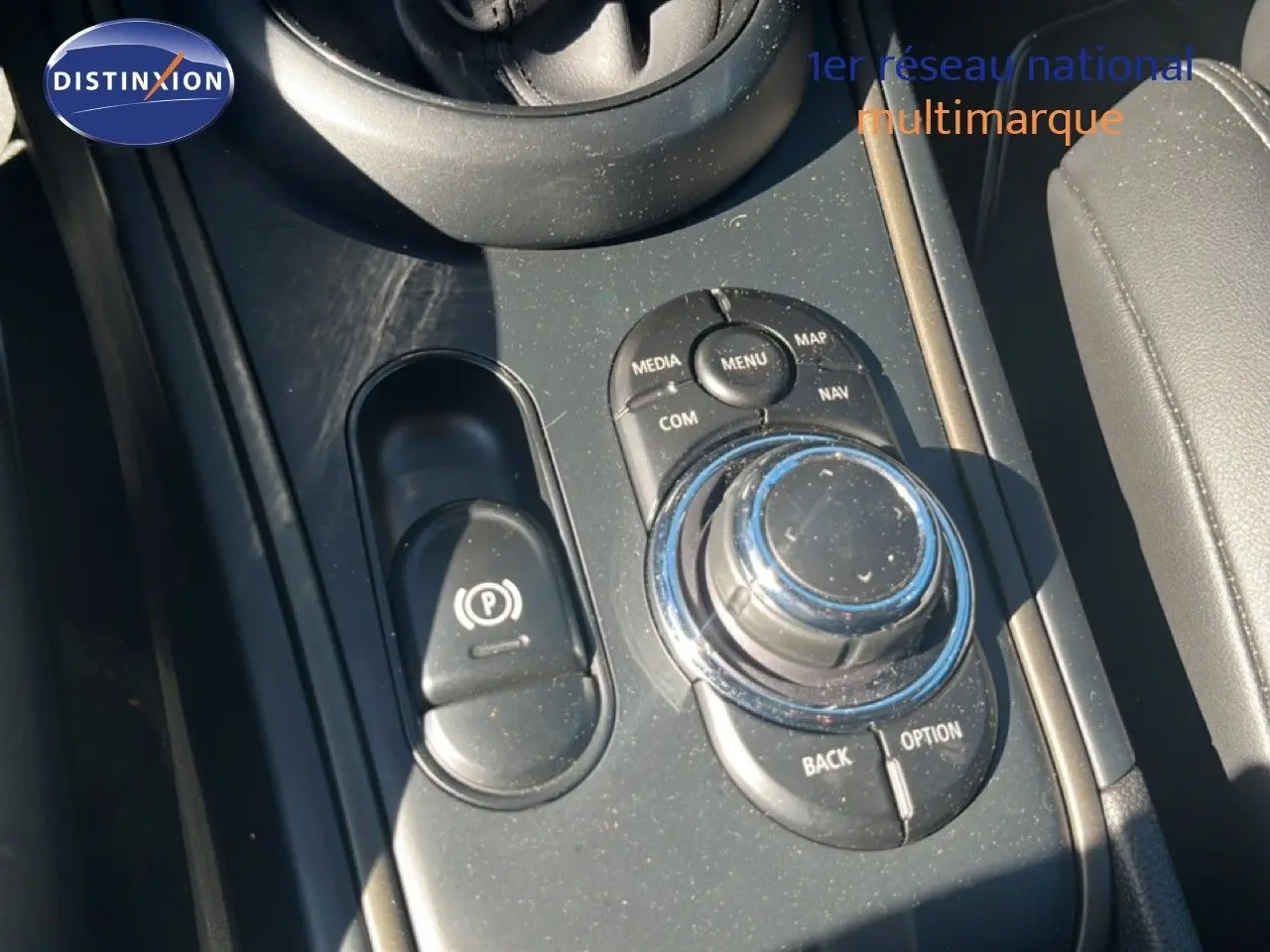 Gros plan sur la console centrale avec molette de contrôle et frein à main électrique du MINI Countryman 2023.