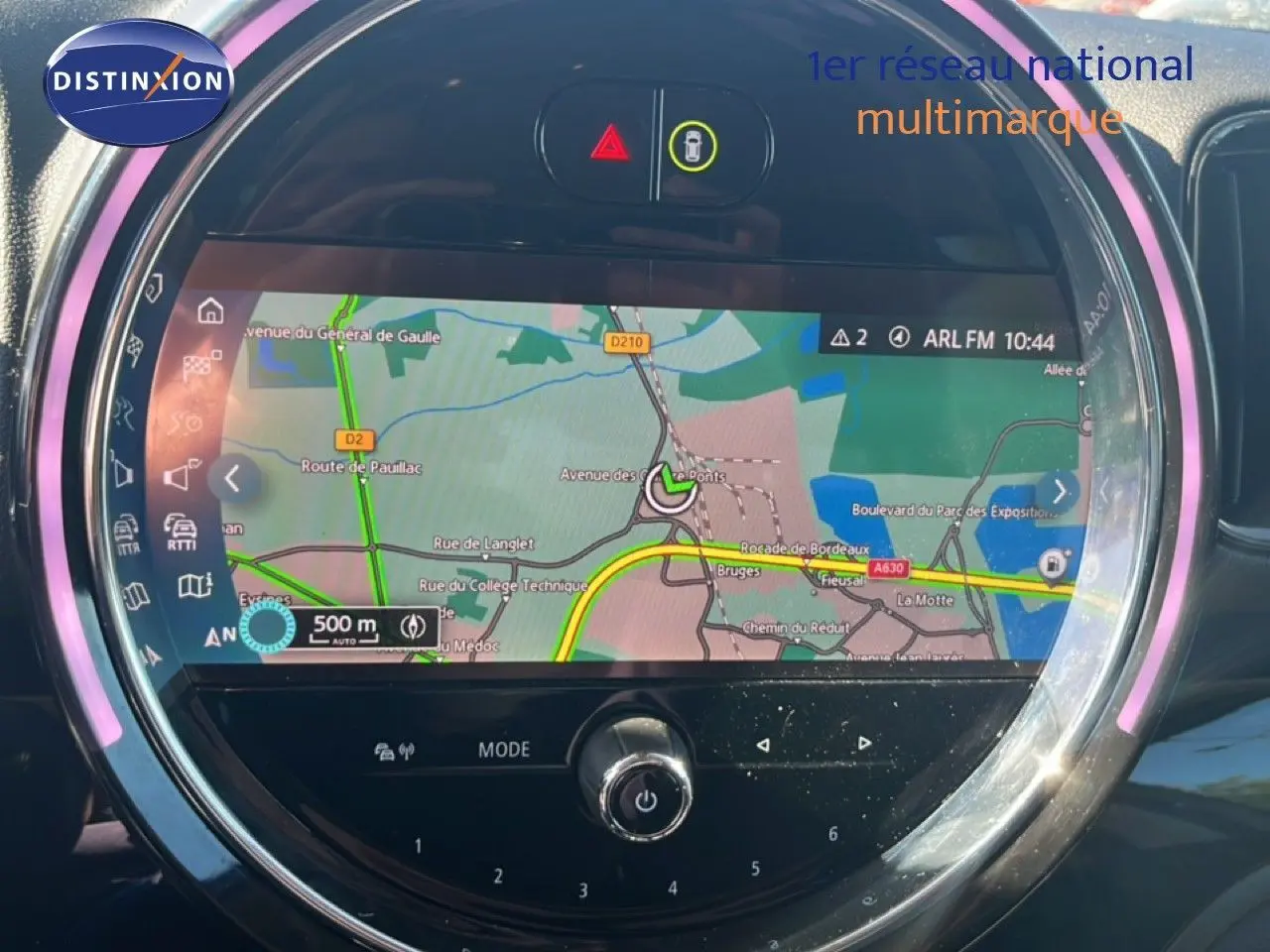 Écran central rond du MINI Countryman 2023 affichant la navigation GPS avec interface lumineuse LED rose pâle.
