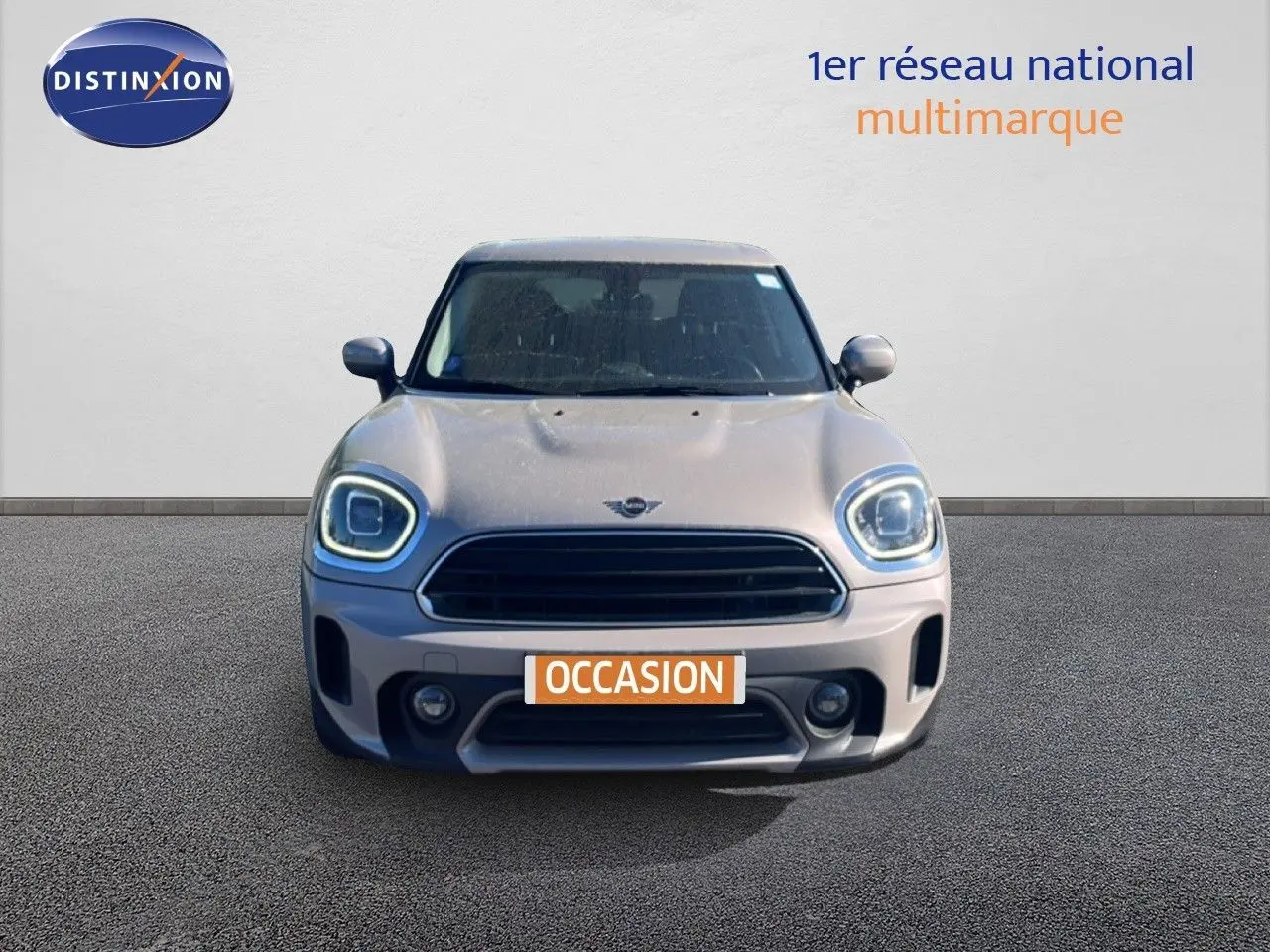 Vue frontale d'une MINI Countryman Cooper 2023 en gris rooftop metal avec phares LED allumés et plaque occasion.