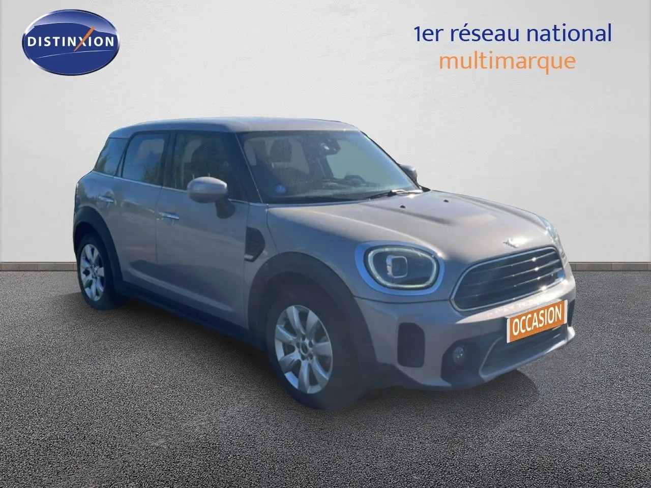 Vue 3/4 avant droit d'un MINI Countryman Cooper 2023 gris rooftop, avec calandre noire et jantes argentées.