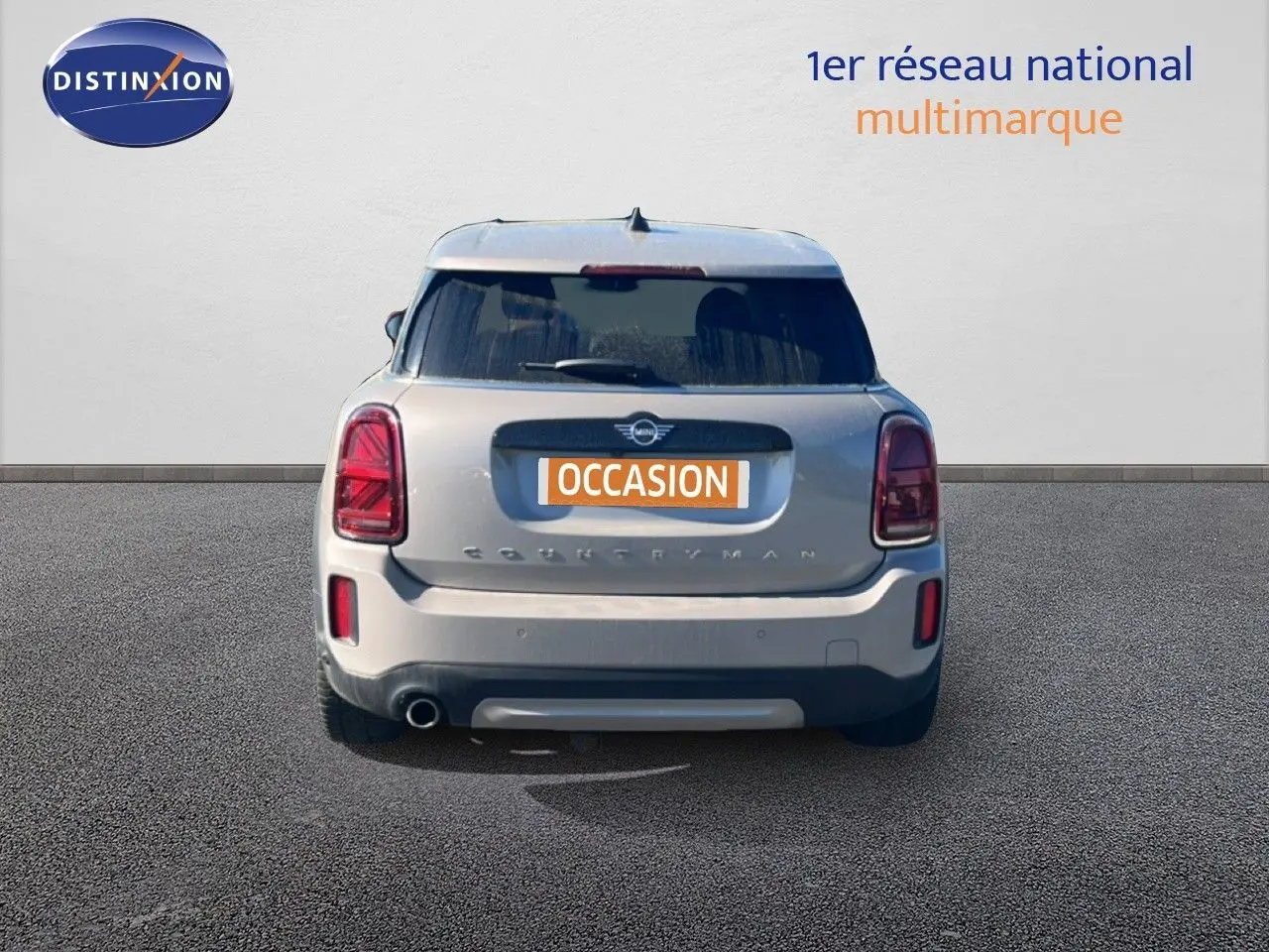 Vue arrière d'un MINI Countryman Cooper 2023 gris rooftop avec feux arrière LED et plaque d'occasion visible.