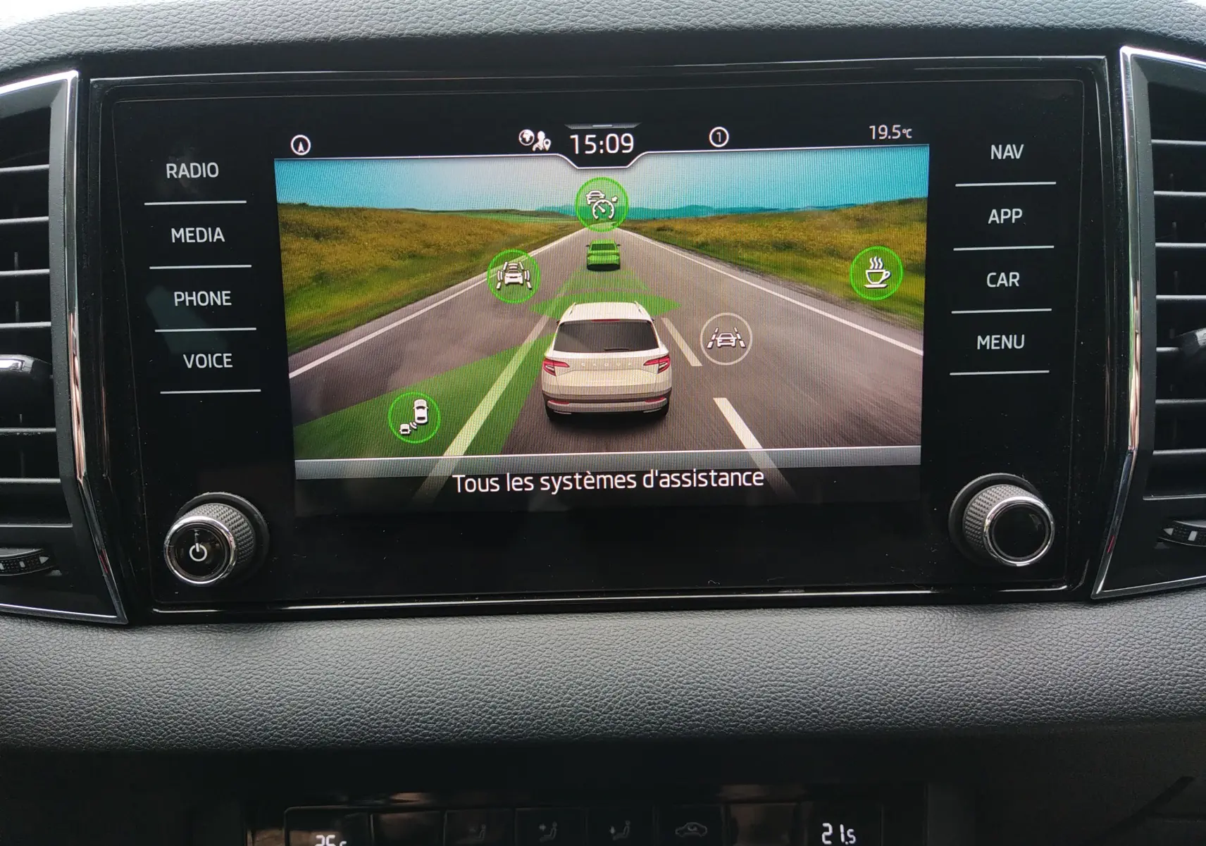 Écran central du Skoda Karoq gris 2021 montrant l'interface des systèmes d'assistance à la conduite.