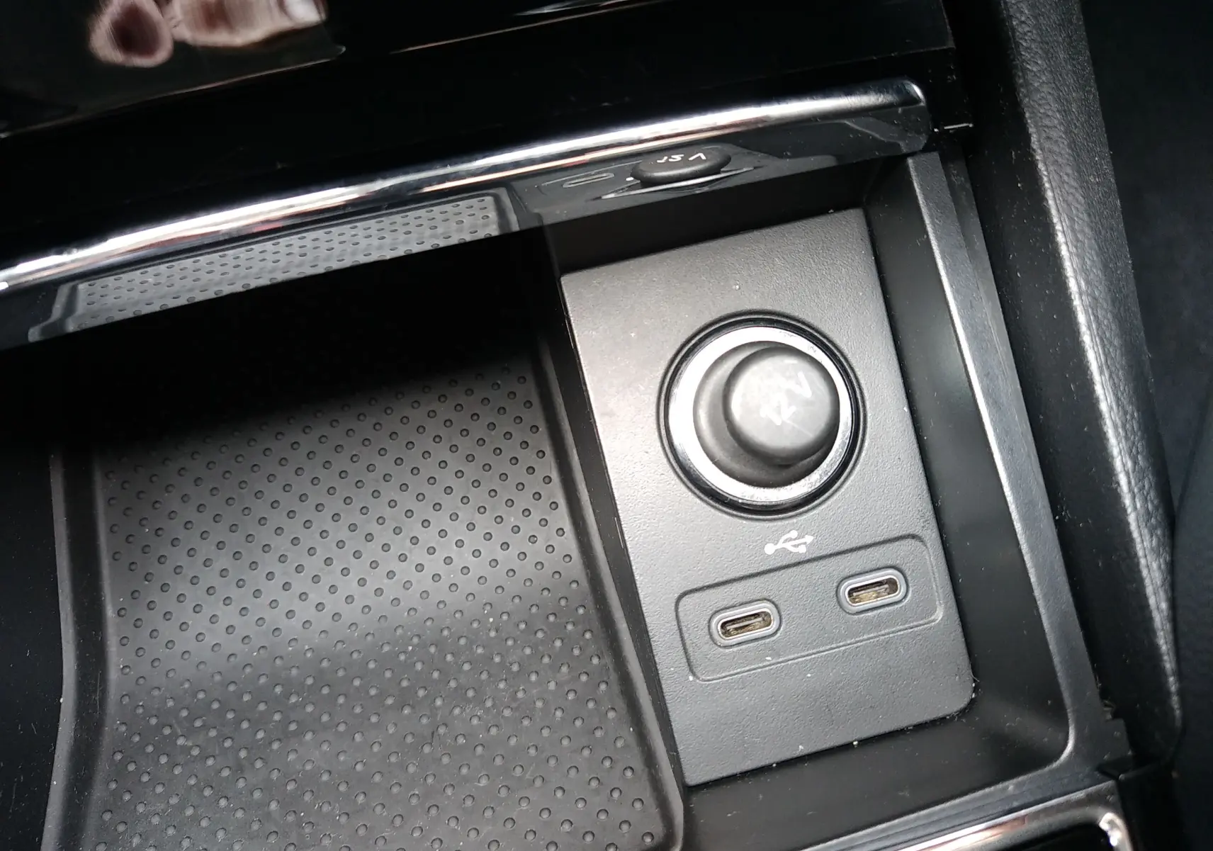 Gros plan sur la console centrale noire d’un Skoda Karoq 2021, montrant prise 12V et deux ports USB-C.