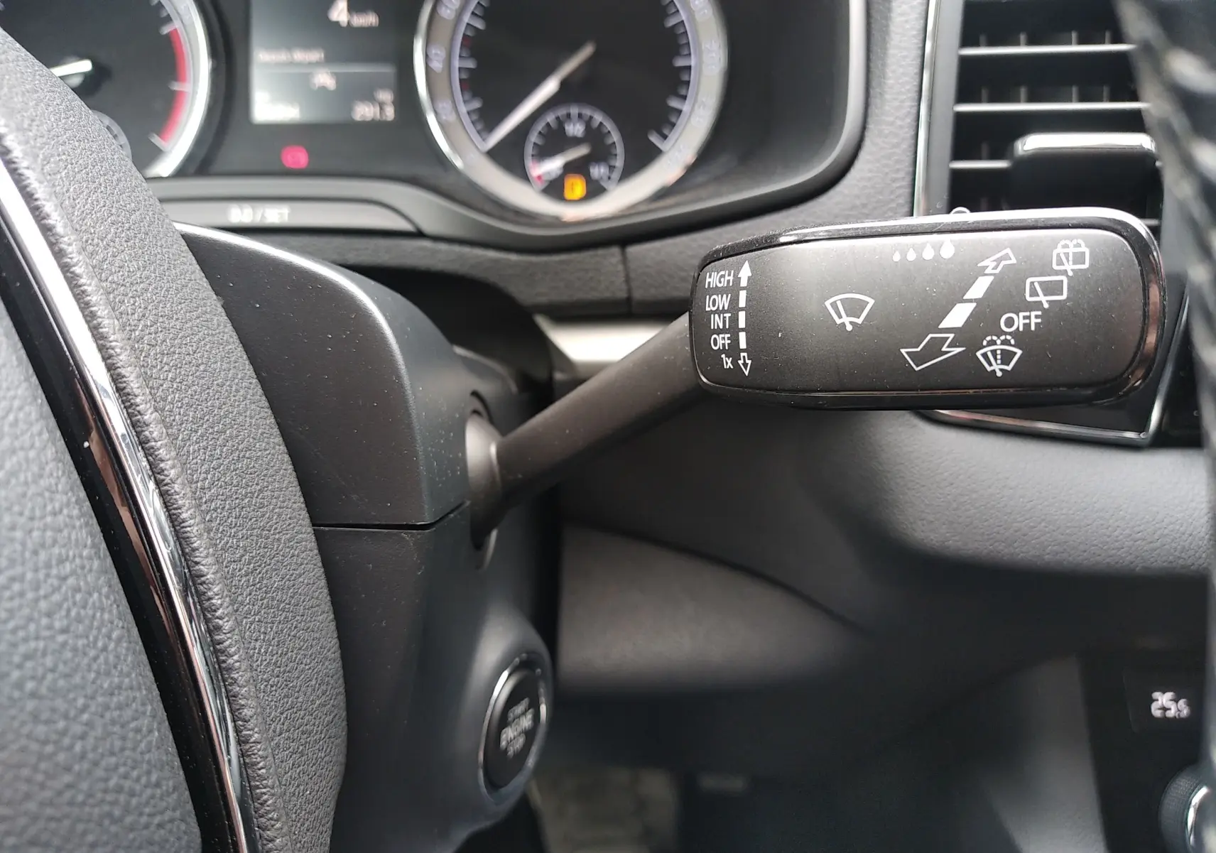 Gros plan sur la manette d'essuie-glace à droite du volant dans l'habitacle gris foncé d'un Skoda Karoq 2021.