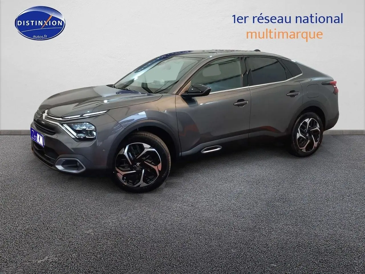Citroën C4 X gris platinium métal en 3/4 avant droit, avec jantes bi-ton et lignes fluides modernes.
