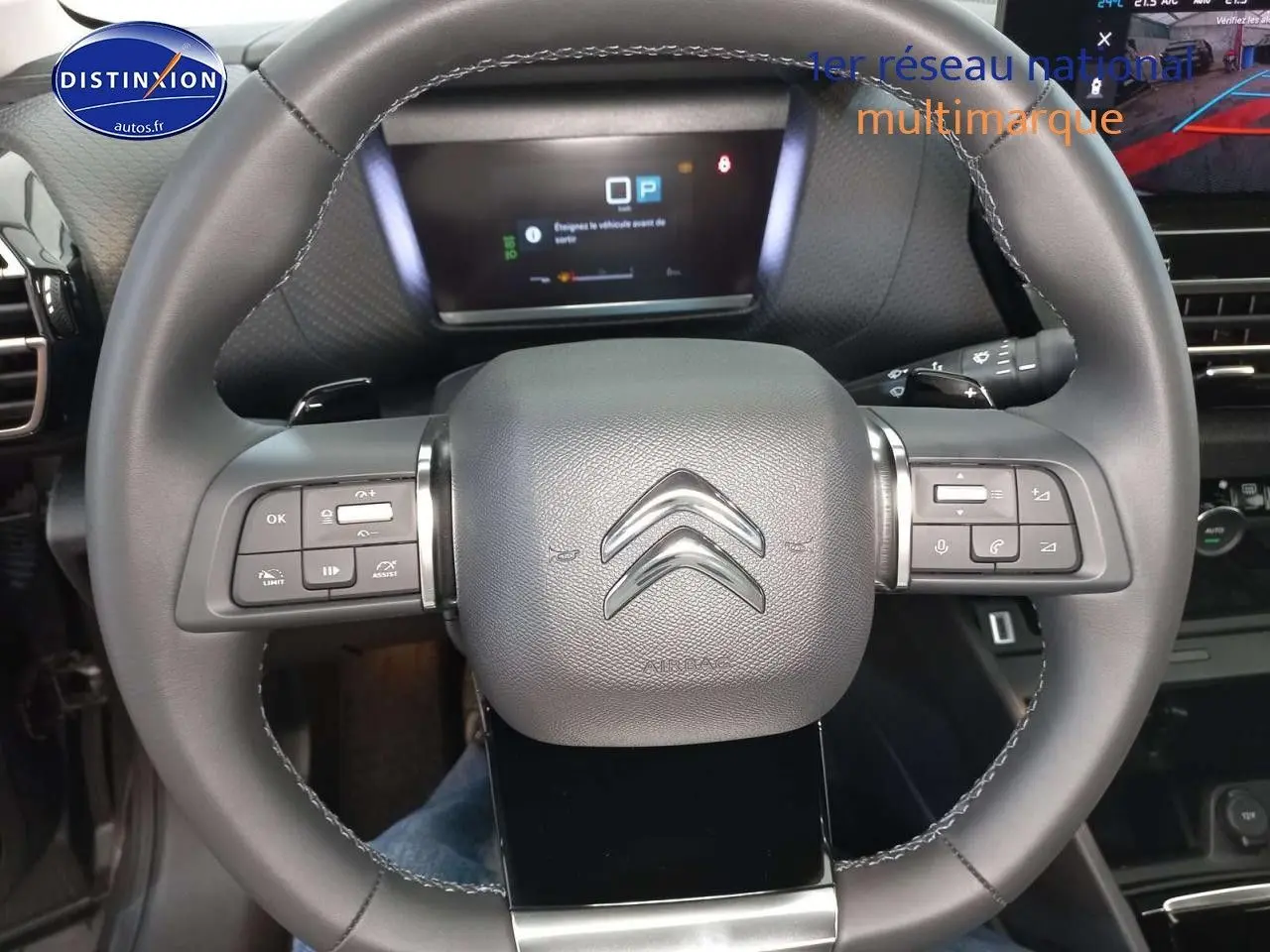 Volant en cuir noir avec commandes intégrées et tableau de bord numérique d'une Citroën C4 X gris platinium 2023.