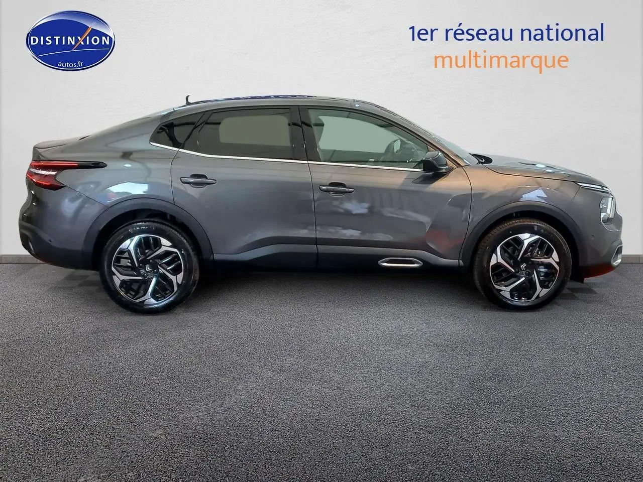 Profil droit d'une Citroën C4 X 2023 gris platinium métal avec jantes bi-ton et lignes fluides élégantes.