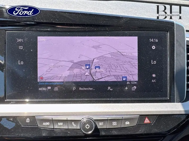 Écran tactile central du tableau de bord de l’Opel Grandland noir, affichant la navigation GPS en plein jour.