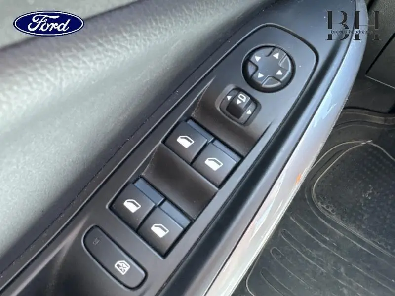 Gros plan sur les commandes des vitres électriques et rétroviseurs côté conducteur d'un Opel Grandland noir.