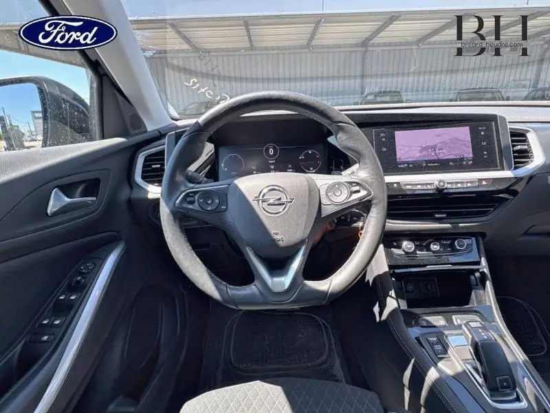 Vue intérieure du poste de conduite de l'Opel Grandland noir avec volant cuir multifonction et écran tactile central.