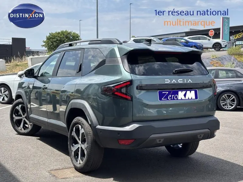 Vue 3/4 arrière droite du Dacia Bigster 2025 vert foncé avec barres de toit et feux arrière LED distinctifs.