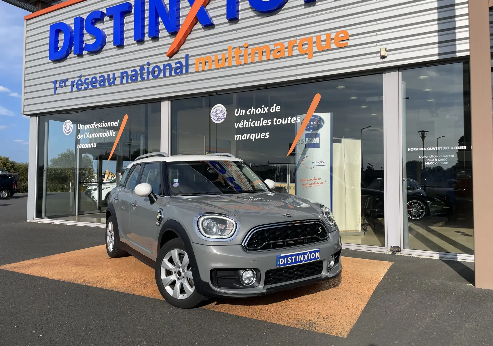 MINI Countryman F60 hybride Moonwalk Grey en 3/4 avant droit devant un showroom Distinxion.