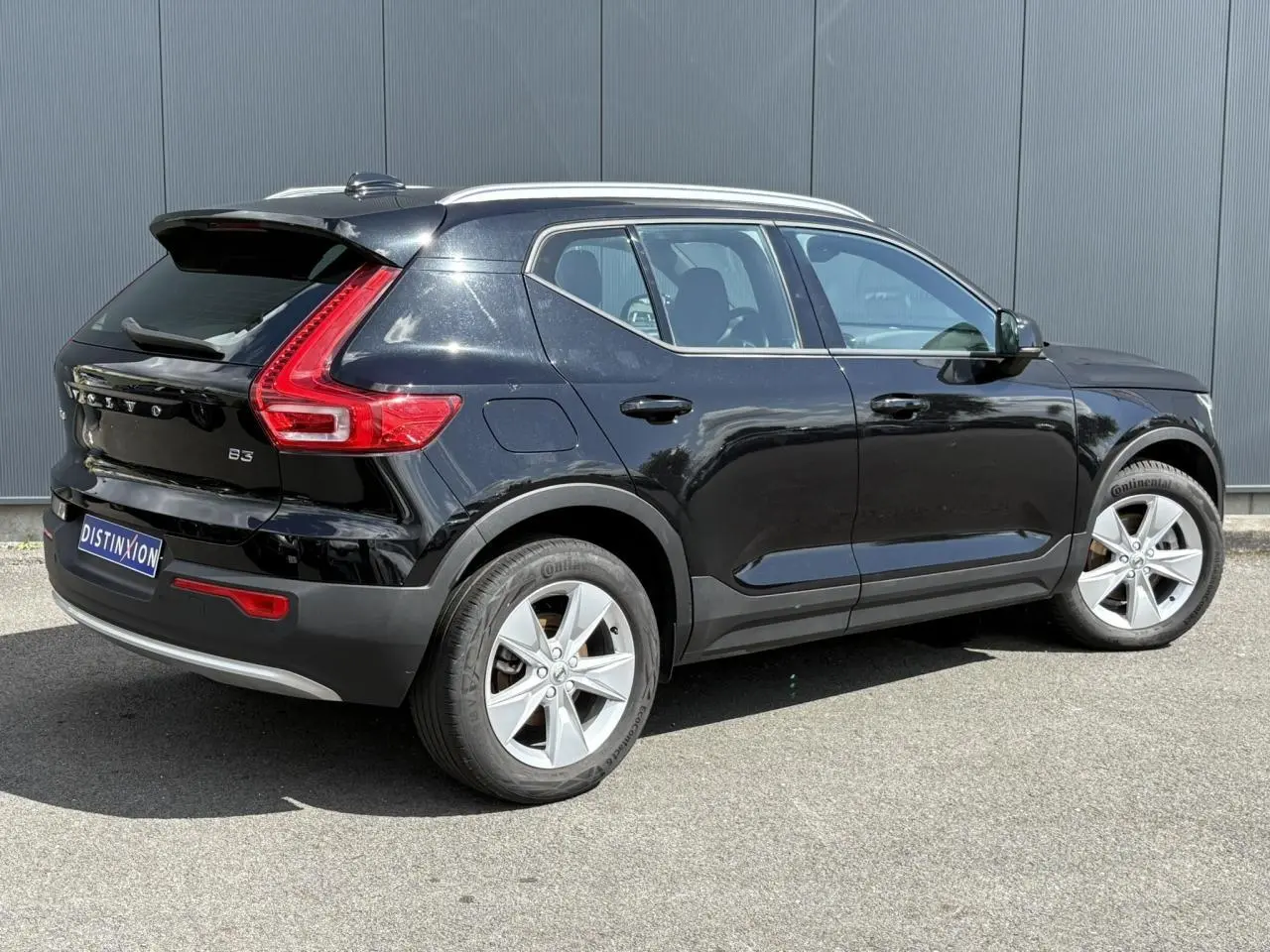 Volvo XC40 noir Onyx vue 3/4 arrière droit, avec feux arrière en forme de L et jantes alliage 18 pouces.