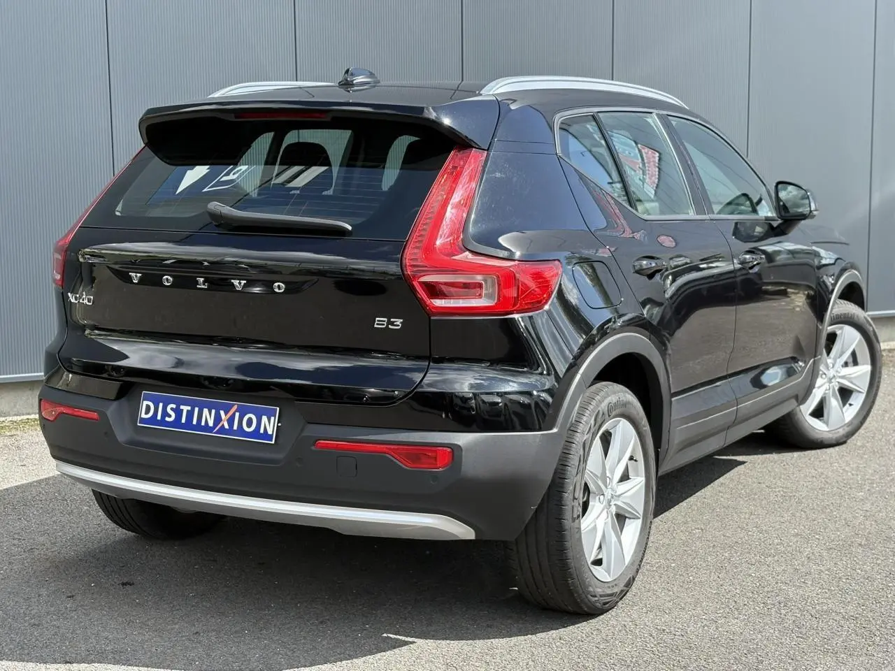Vue 3/4 arrière droite du Volvo XC40 noir Onyx avec feux arrière LED et jantes alliage 18 pouces.