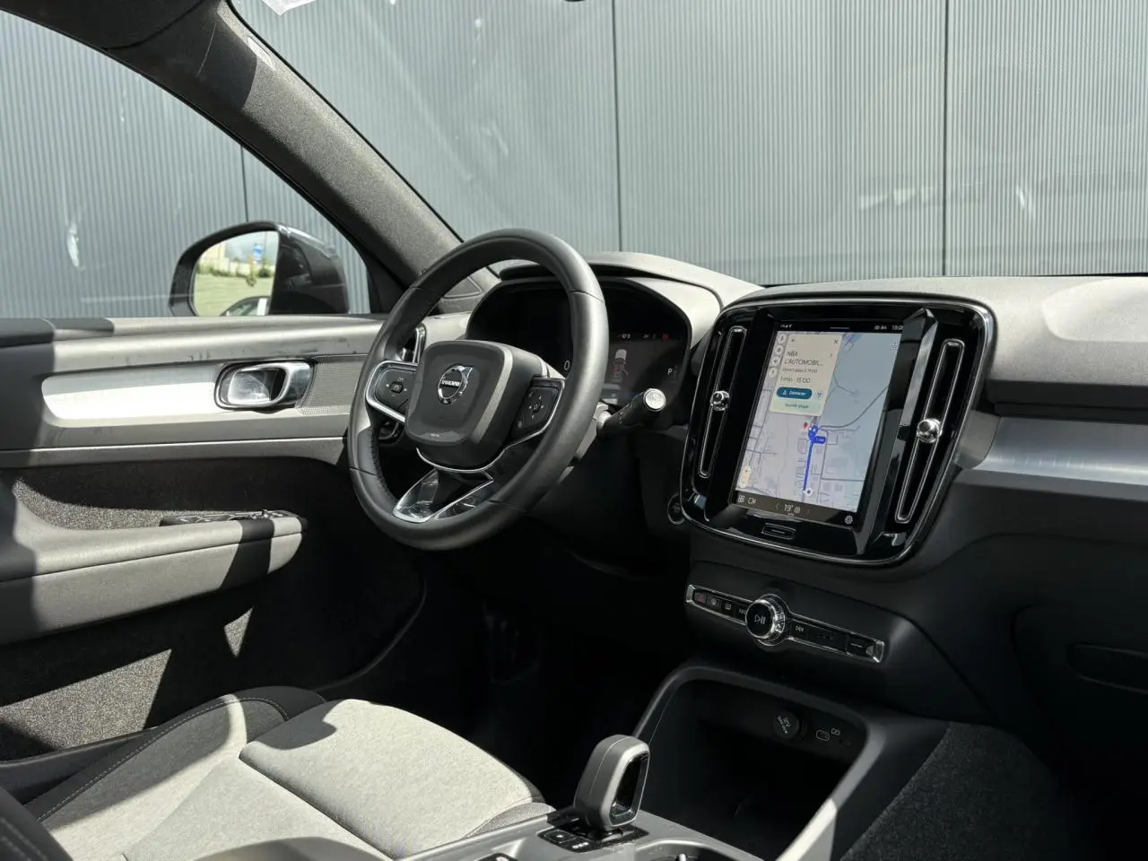 Intérieur du Volvo XC40 B3 MHEV 2024, vue côté gauche sur tableau de bord et écran tactile avec navigation.