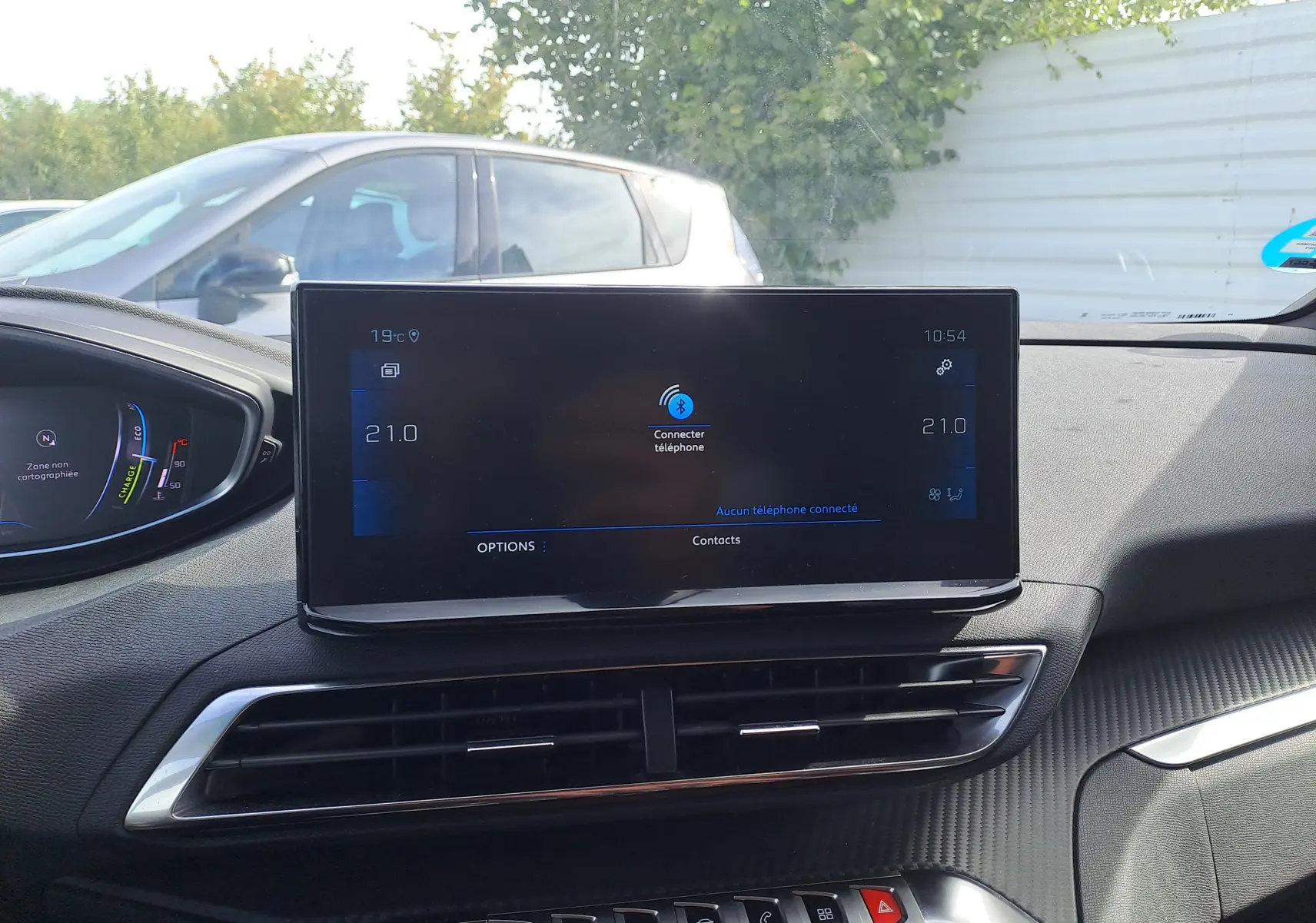 Vue intérieure du tableau de bord du Peugeot 3008 gris platinium 2024, écran tactile central et commandes climatisation visibles.