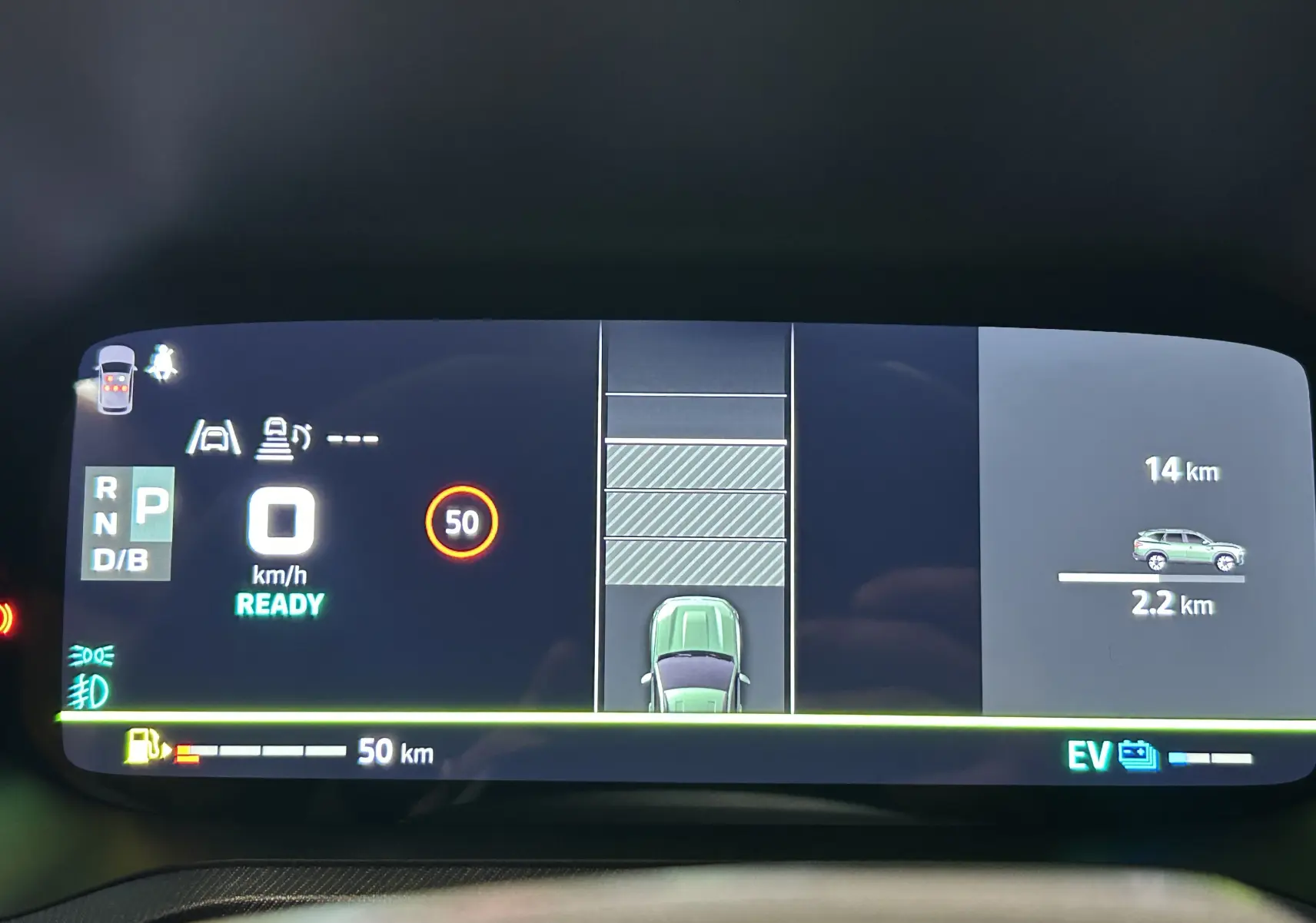 Tableau de bord numérique du Dacia Bigster affichant la vitesse, la consommation et l'assistance au stationnement en vue centrale.