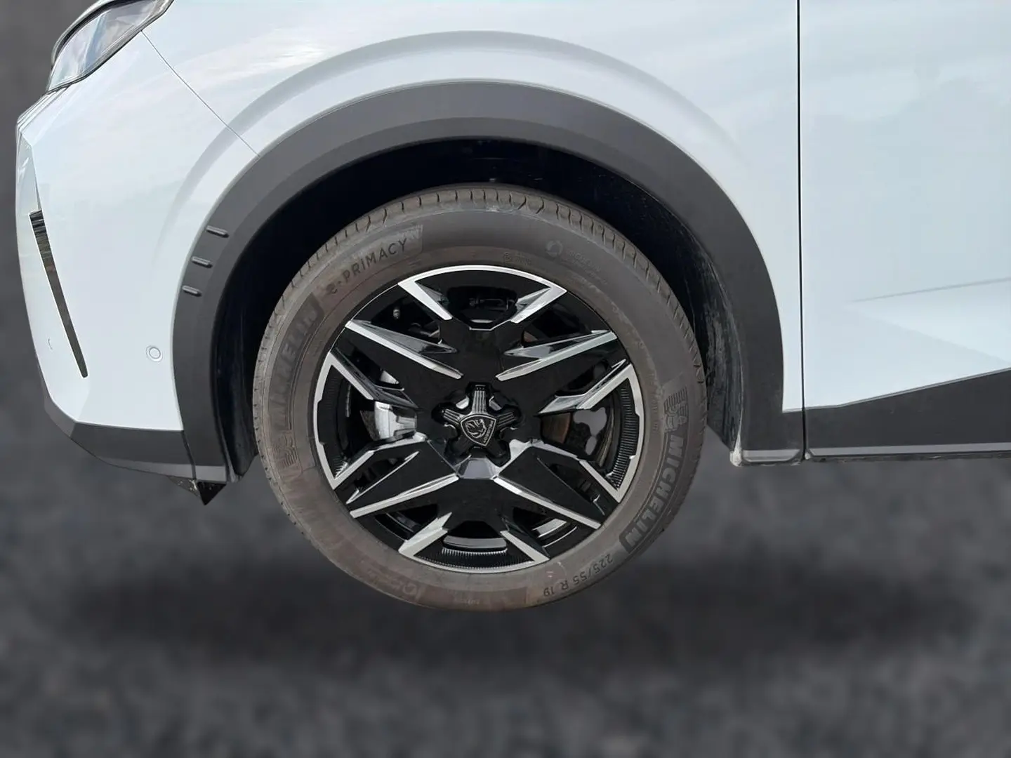 Gros plan sur la roue avant droite noire et argentée du Peugeot 3008 blanc, soulignant la jante alu distinctive.
