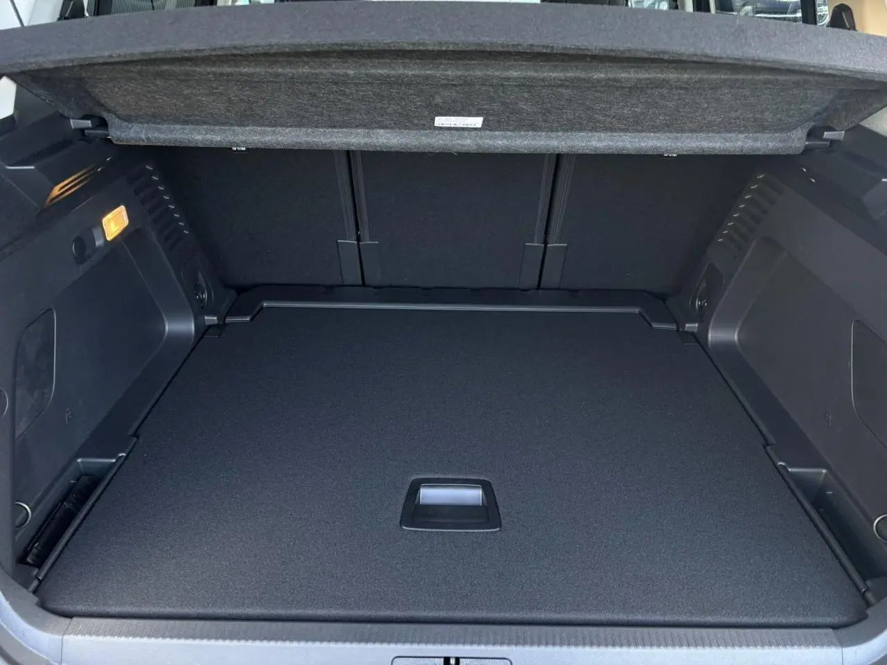 Coffre ouvert du Citroën C5 Aircross gris Platinium, montrant le plancher plat et la trappe de rangement intégrée.