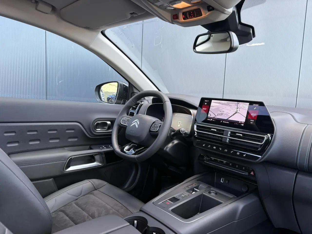 Vue intérieure côté conducteur du Citroën C5 Aircross 2025 avec tableau de bord noir et écran tactile GPS.