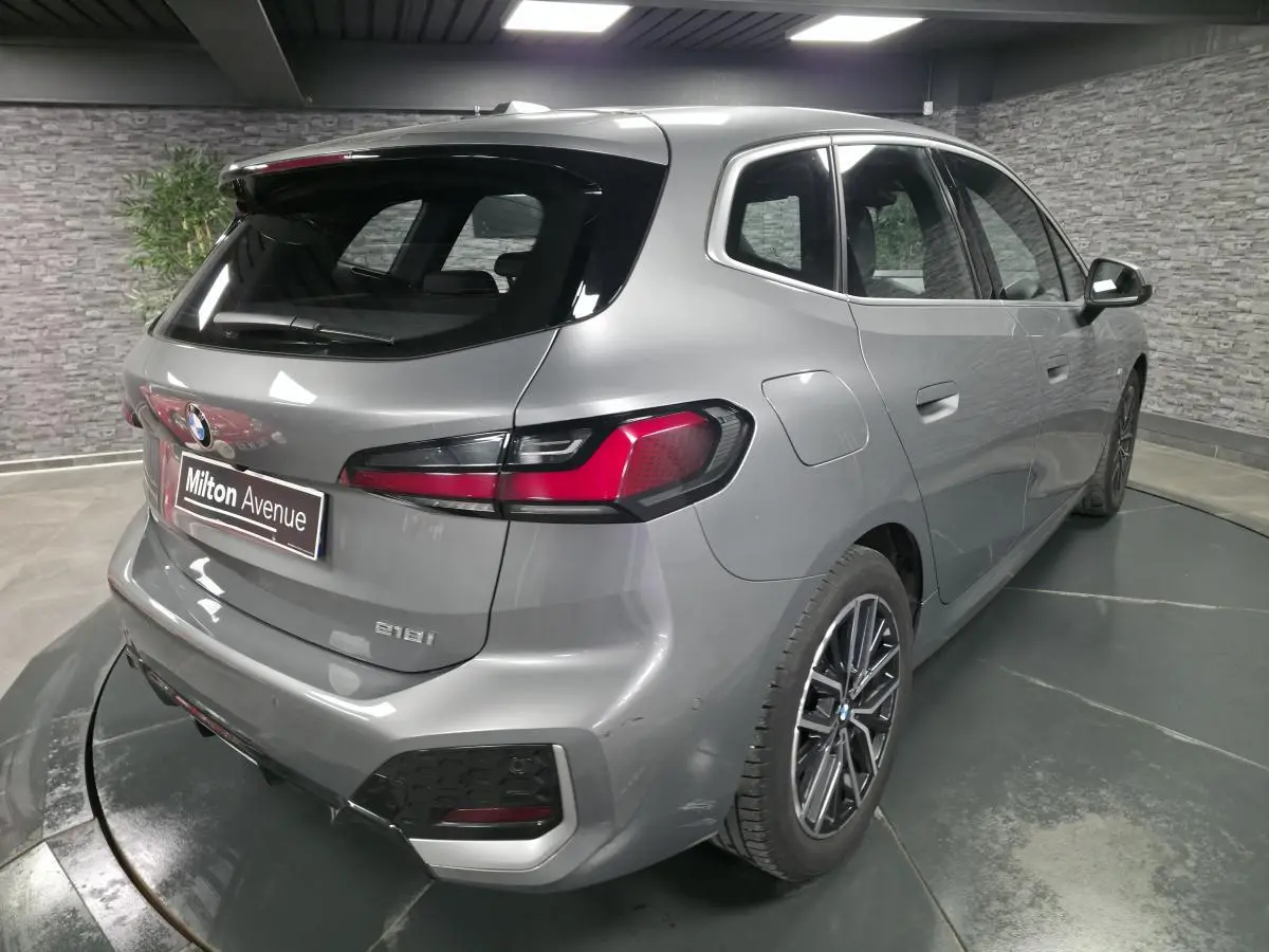 Vue 3/4 arrière droite d'une BMW Série 2 218i Active Tourer gris métallisé avec jantes alliage 18 pouces.