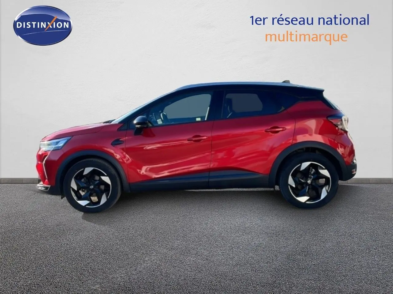 Profil côté gauche du Renault Captur 2025 rouge Désir métallisé avec toit noir, jantes noires et design moderne.