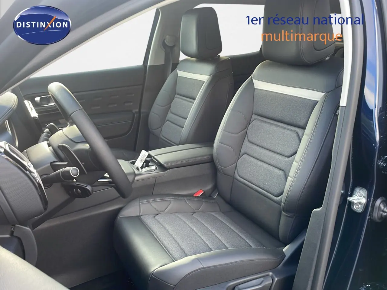 Vue intérieure côté conducteur du Citroën C5 Aircross 2025 bleu Eclipse Metal, sièges en cuir noir et tissu gris.