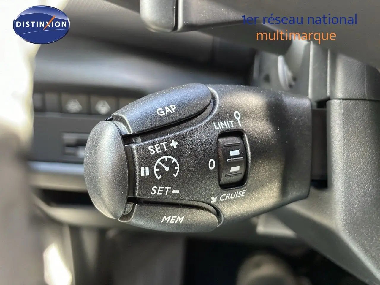 Gros plan sur la commande de régulateur de vitesse du Citroën C5 Aircross 2025, intérieur noir avec détails blancs.