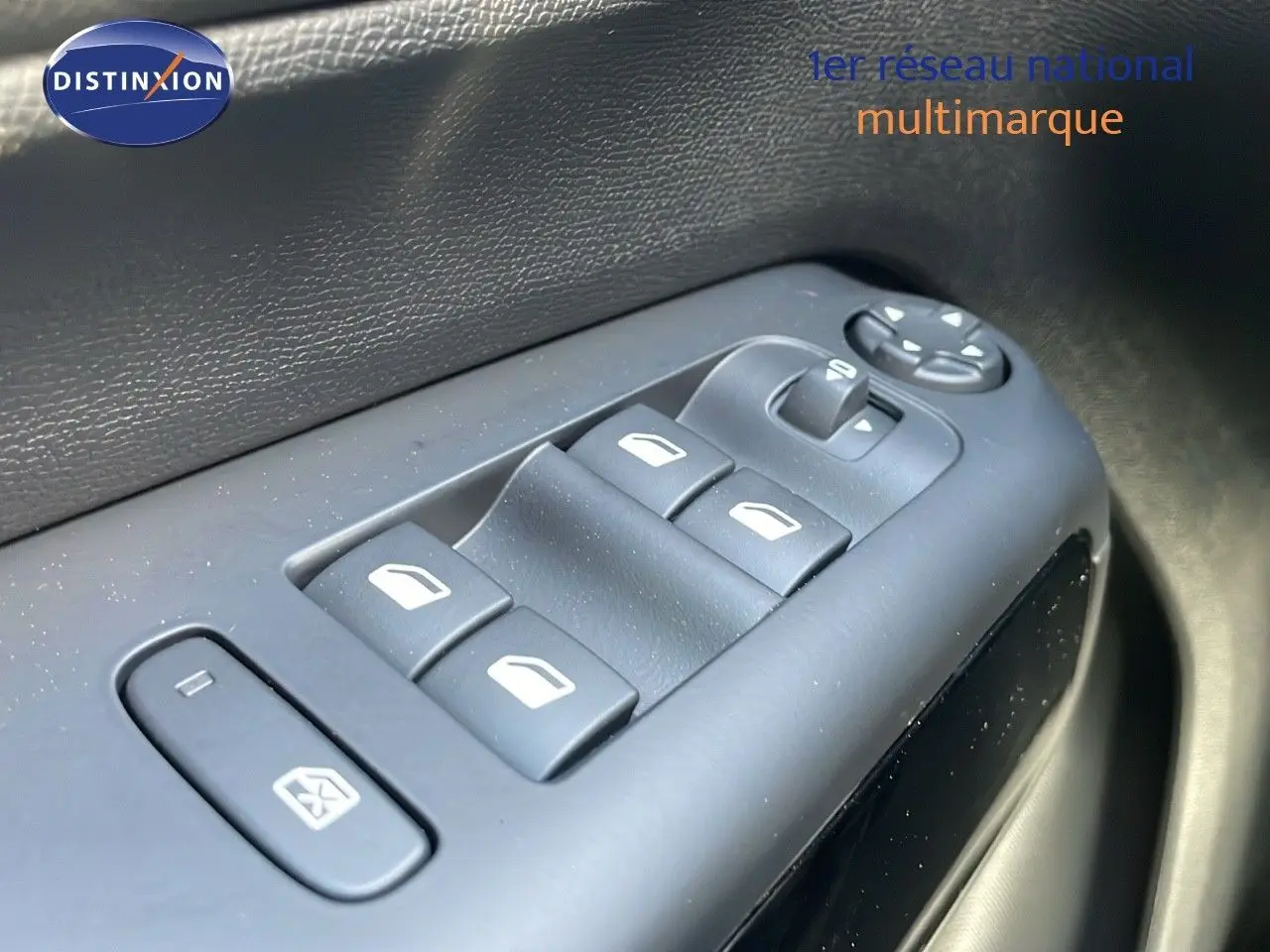 Gros plan sur les commandes des vitres électriques côté conducteur d’un Citroën C5 Aircross 2025 bleu Eclipse Metal.