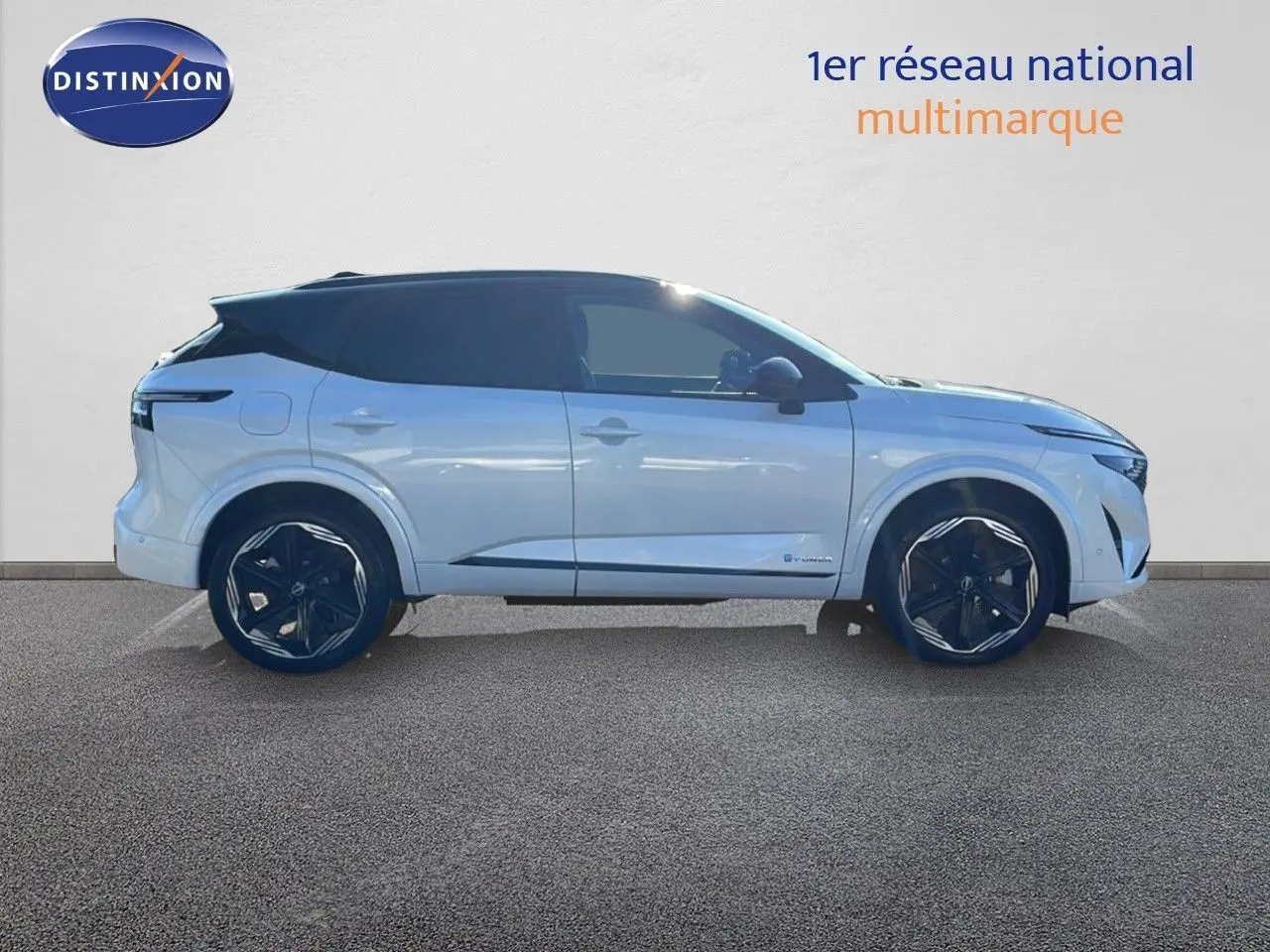 Profil droit du Nissan Qashqai 2025 blanc nacré avec toit noir et jantes noires distinctives en alliage.