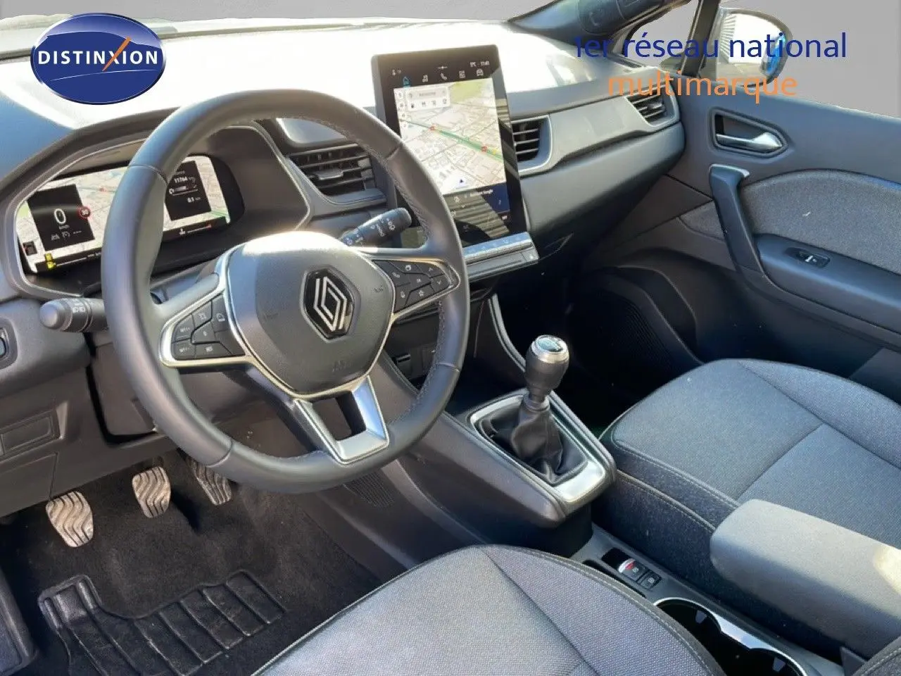 Vue intérieure côté conducteur du Renault Captur 2025, tableau de bord moderne avec écran tactile vertical et volant cuir noir.