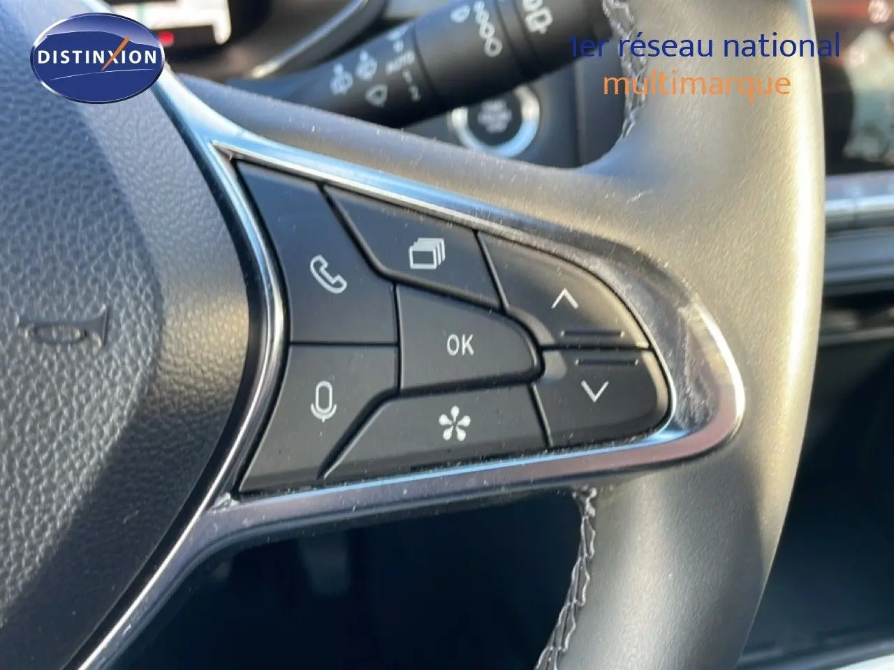 Gros plan sur les commandes au volant du Renault Captur 2025 gris rafale métal avec toit noir, boutons multifonctions visibles.