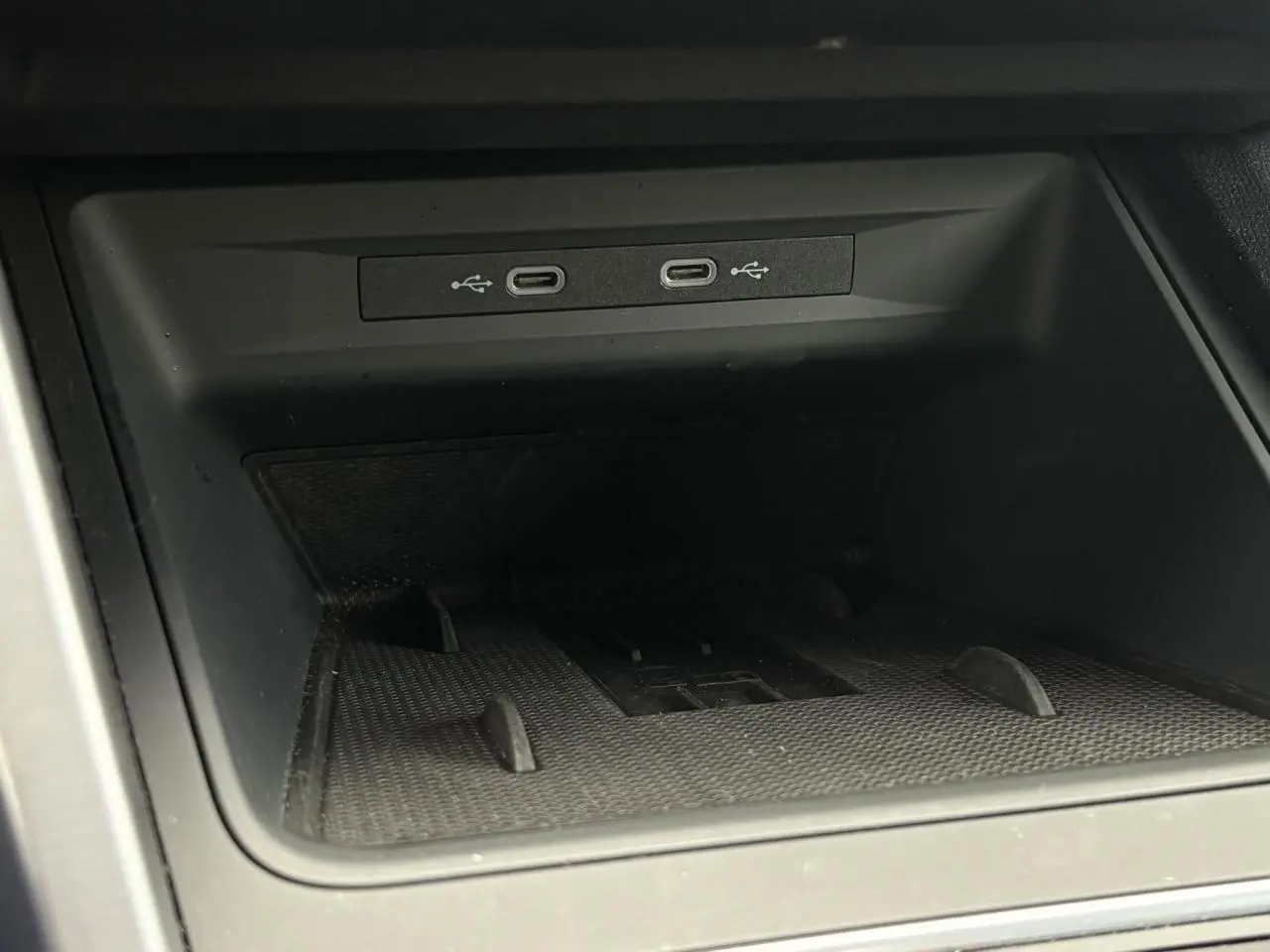 Gros plan sur la connectivité USB-C dans le rangement central du SEAT LEON 2025 noir Minuit.